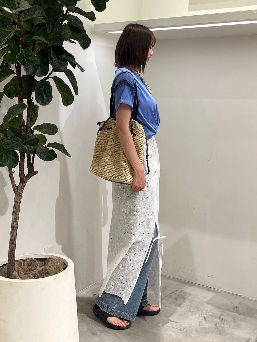 ブルー系のTシャツ/カットソー、ベージュ系のトートバッグ、ブルー系のデニムパンツを着用したレディースの夏コーディネートの4枚目の写真