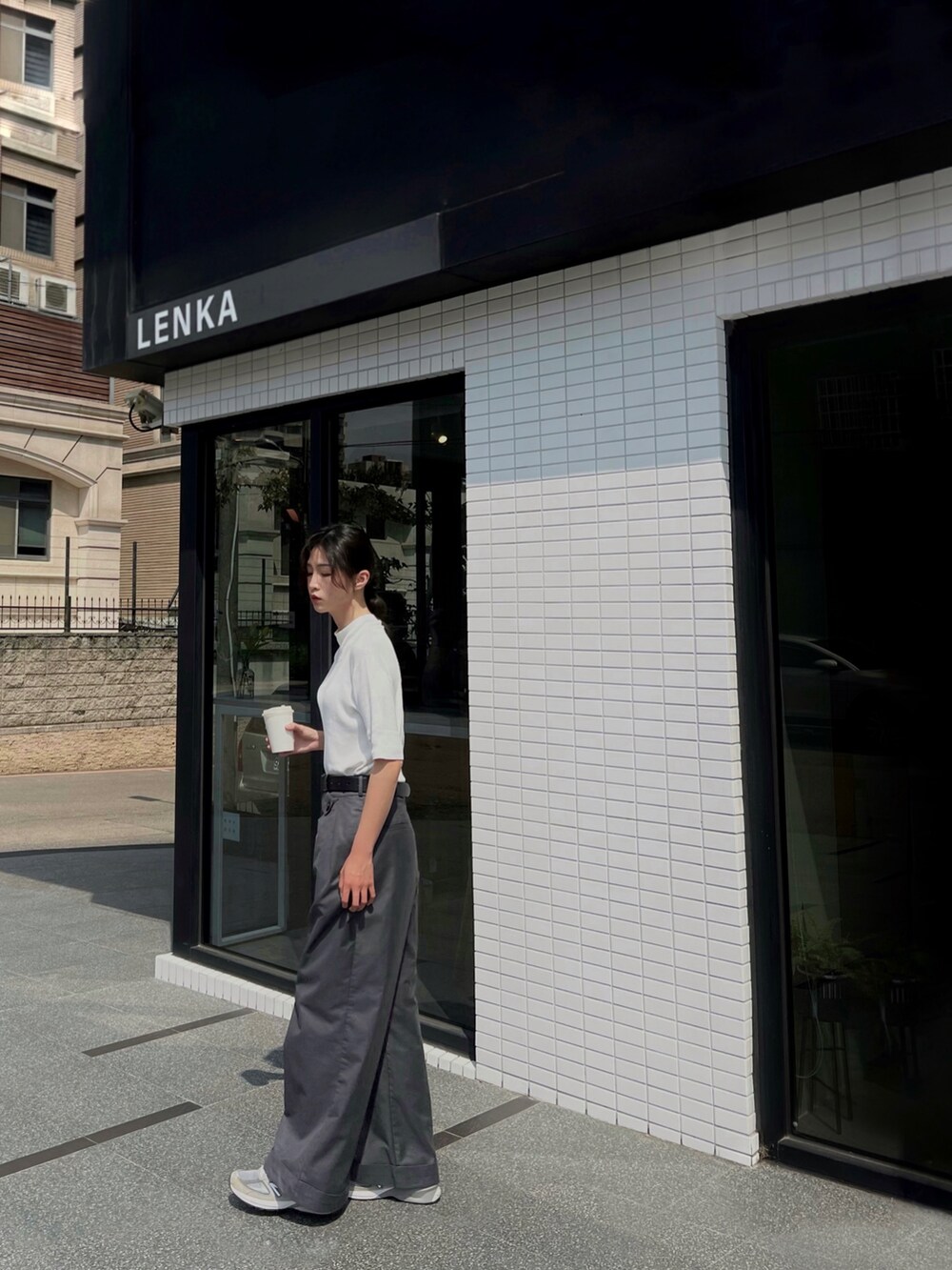 グレー系のスラックス、グレー系のスニーカーを着用したレディースの春コーディネートの2枚目の写真