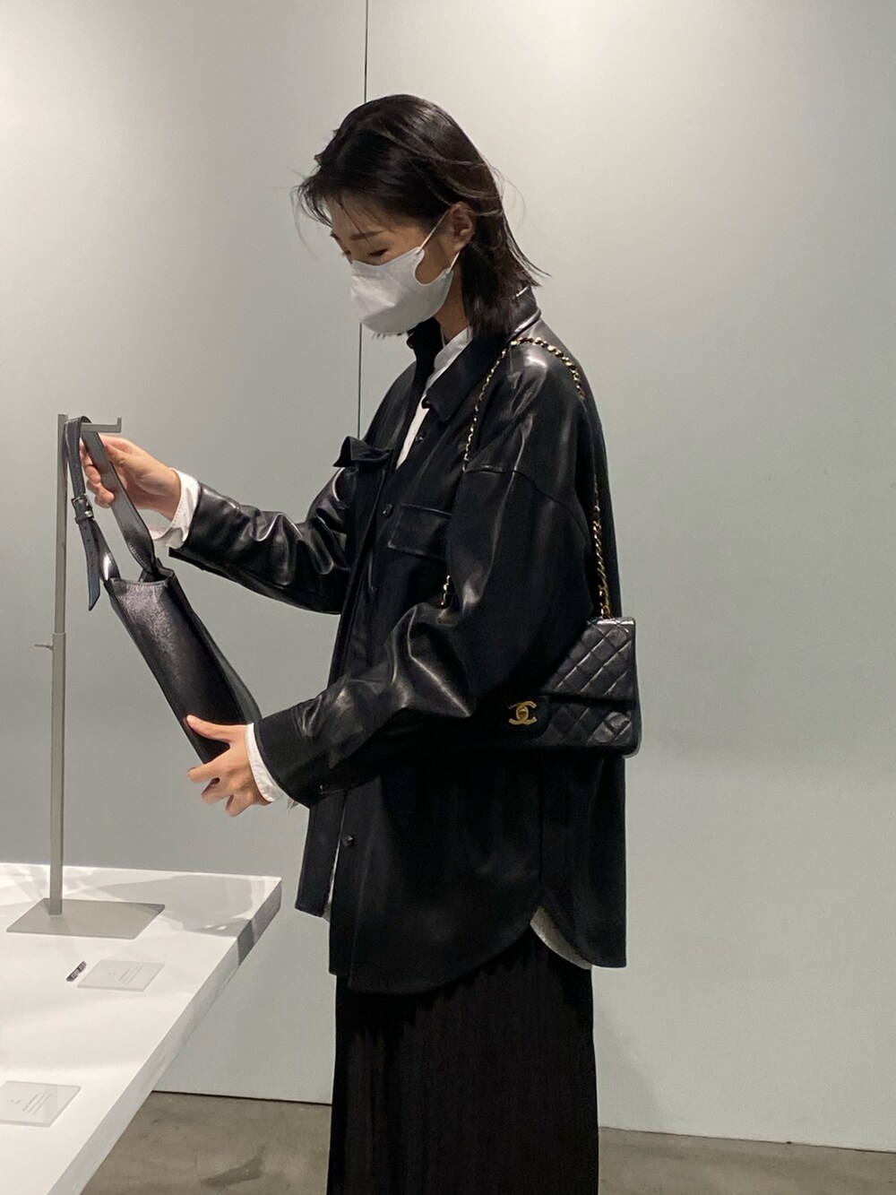 ブラック系のブーツ、ブラック系のジャケット/アウター、ブラック系のショルダーバッグを着用したレディースの秋コーディネートの2枚目の写真