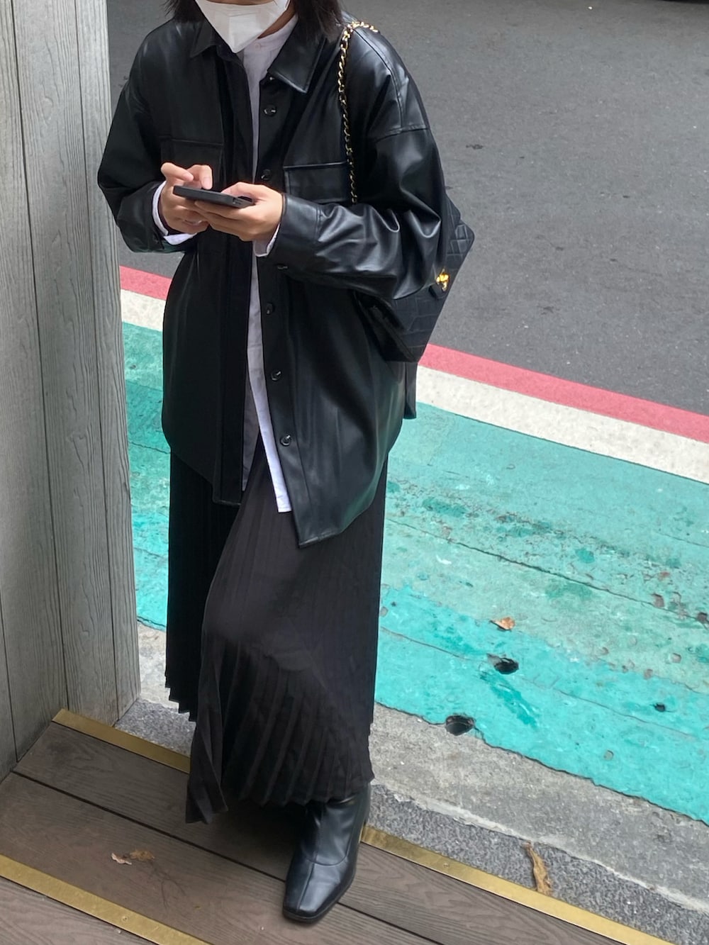 ブラック系のブーツ、ブラック系のジャケット/アウター、ブラック系のショルダーバッグを着用したレディースの秋コーディネートの3枚目の写真