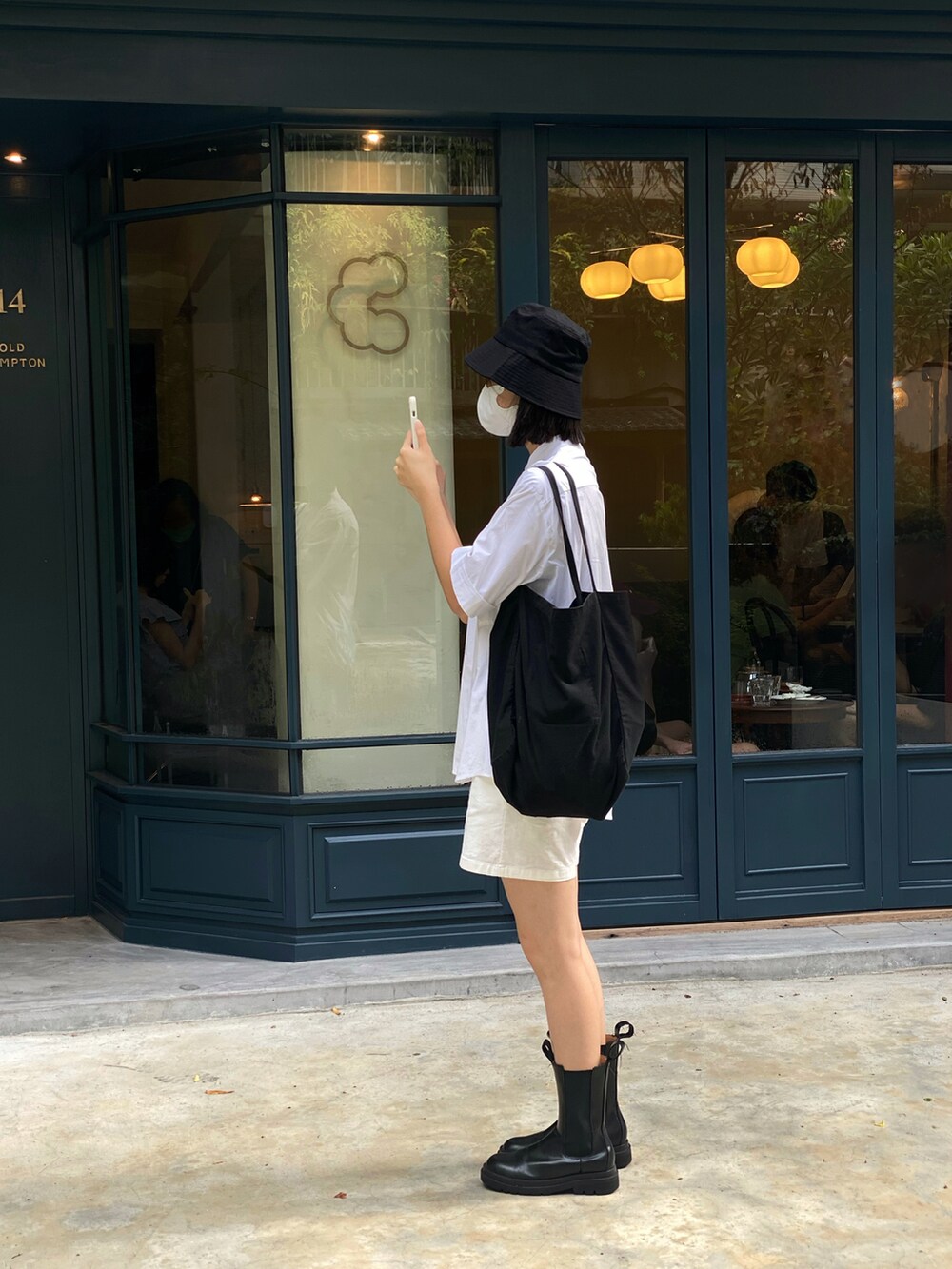 ブラック系のブーツ、ホワイト系のシャツ/ブラウス、ホワイト系のカーゴパンツを着用したレディースの夏コーディネートの2枚目の写真