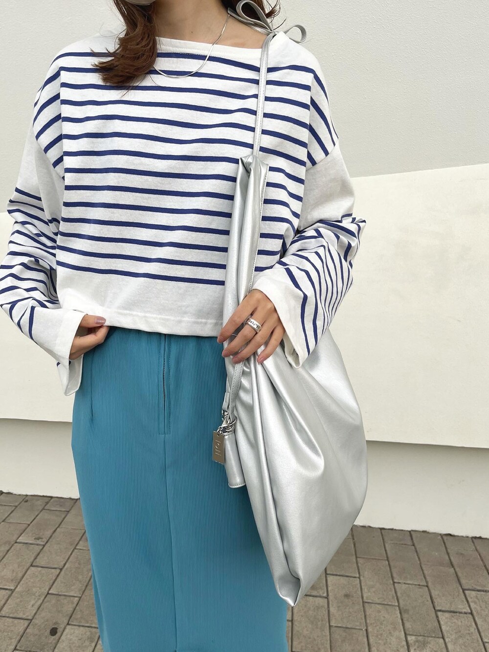 ブルー系のスカート、ブルー系のTシャツ/カットソー、ブラック系のローファーを着用したレディースの冬コーディネートの2枚目の写真