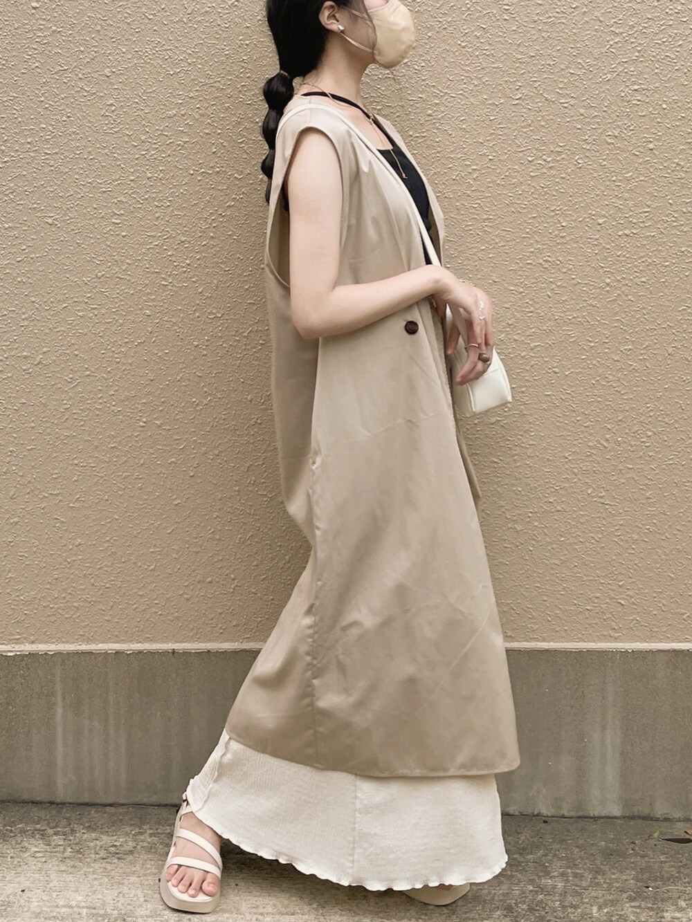 ブラック系のキャミソール、ホワイト系のスカート、ホワイト系のボストンバッグを着用したレディースの夏コーディネートの4枚目の写真