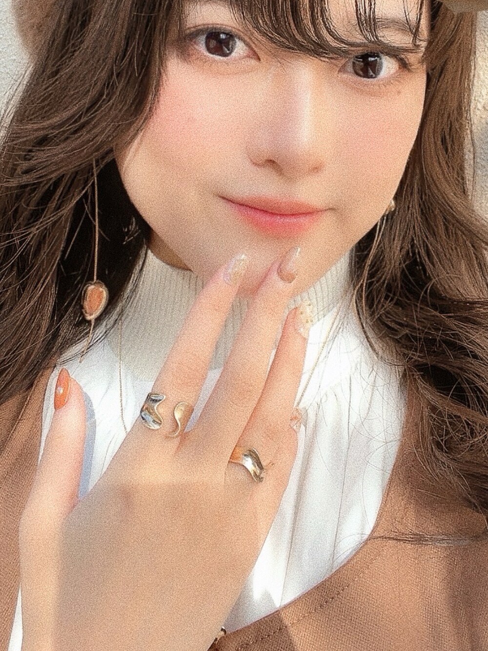 ホワイト系のシャツ/ブラウス、ベージュ系のニット/セーター、ブラウン系のハンドバッグを着用したレディースの冬コーディネートの5枚目の写真