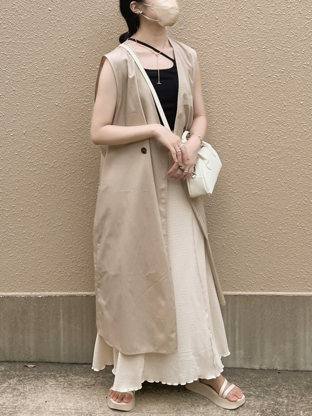 ブラック系のキャミソール、ホワイト系のスカート、ホワイト系のボストンバッグを着用したレディースの夏コーディネートの2枚目の写真