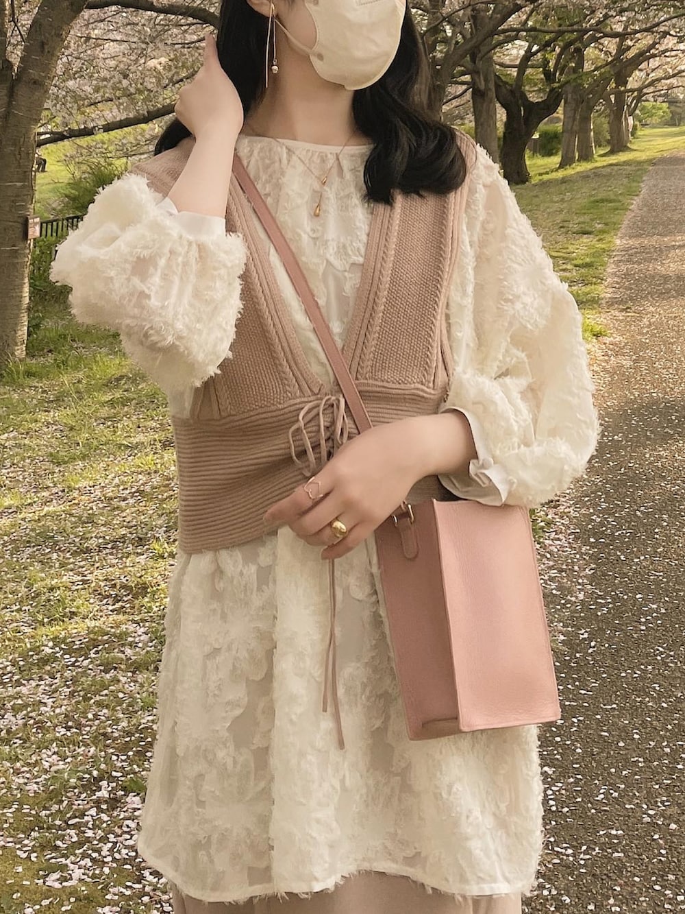 ホワイト系のシャツ/ブラウス、ベージュ系のベスト、ピンク系のショルダーバッグを着用したレディースの春コーディネートの3枚目の写真