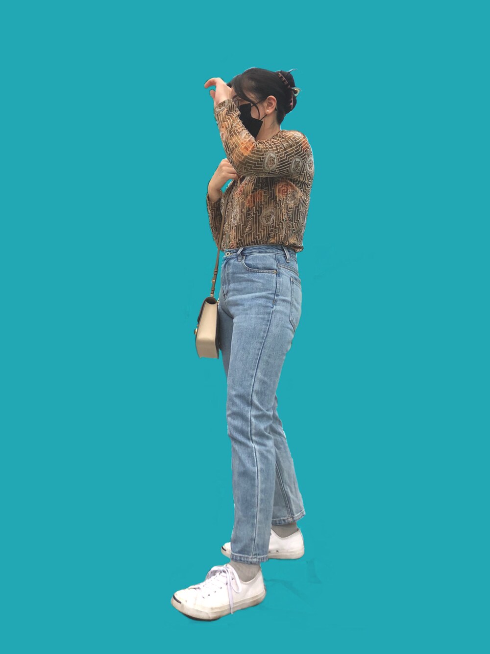 ブルー系のパンツ、ブラック系のスニーカー、ベージュ系のショルダーバッグを着用したレディースの秋コーディネートの2枚目の写真