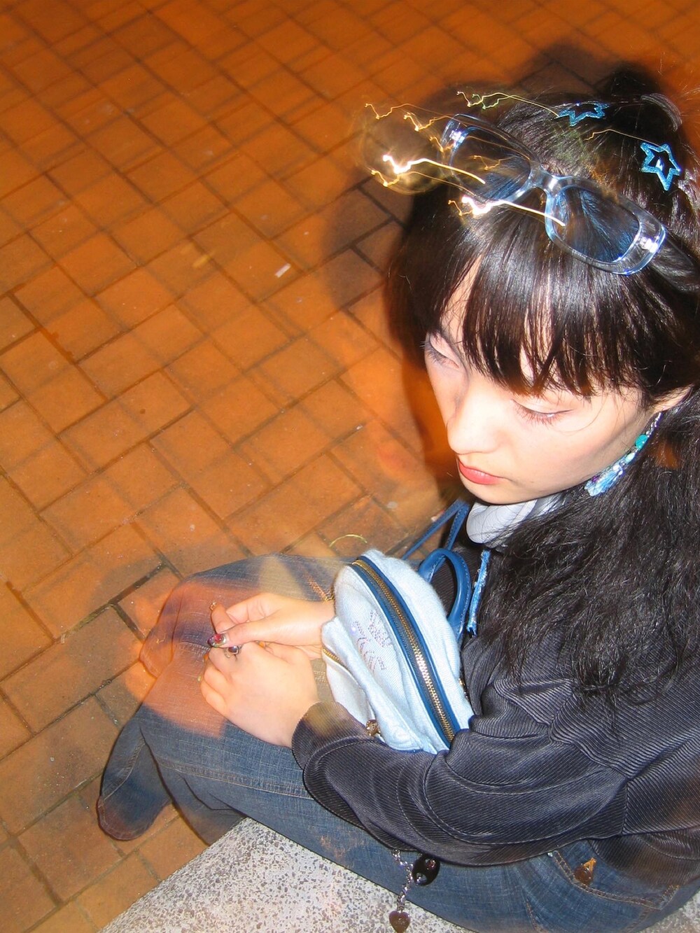 ブルー系のバッグ、ブラック系のサンダル、ブルー系のデニムスカートを着用したレディースの冬コーディネートの4枚目の写真