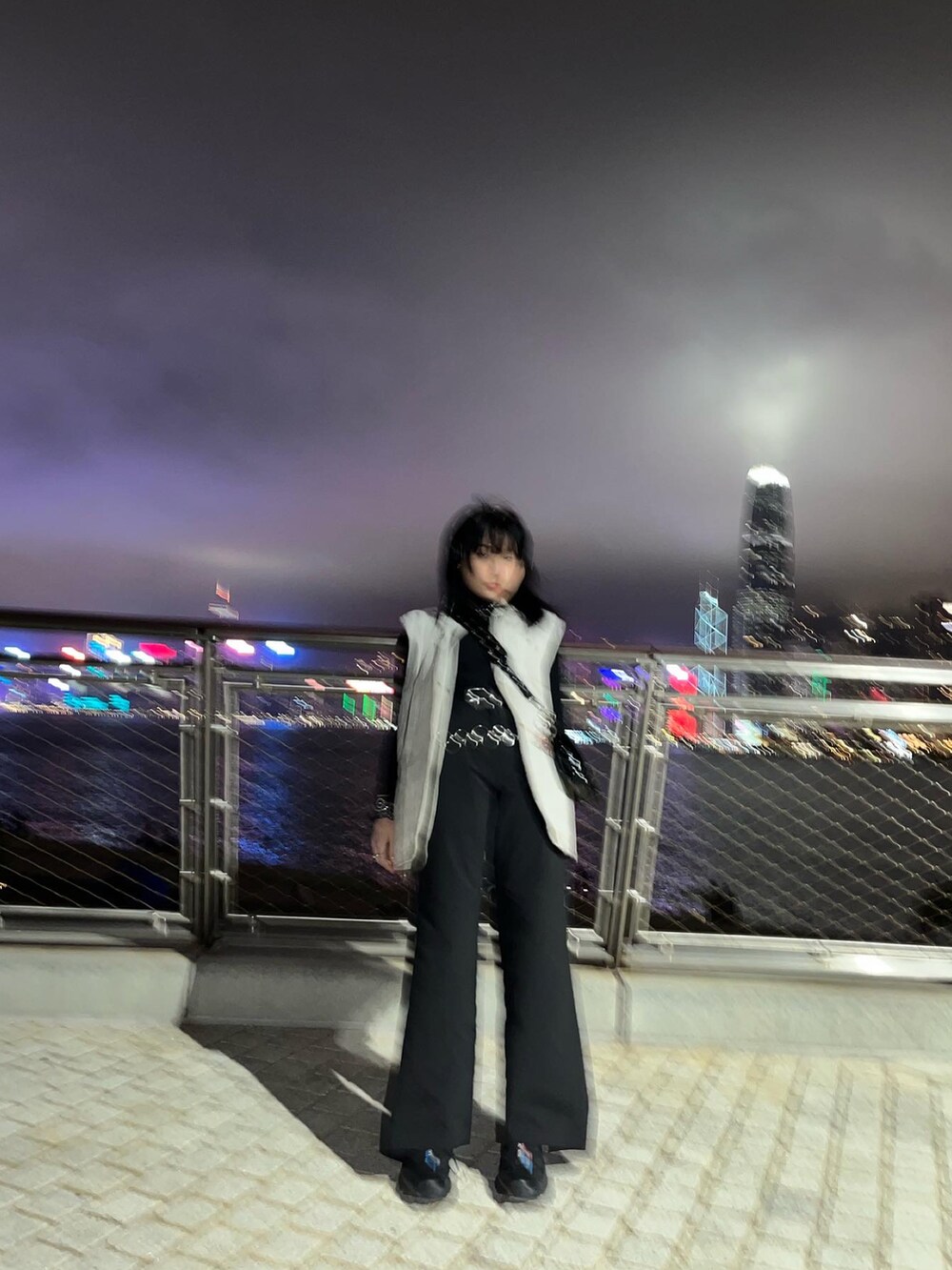 ブラック系のチノパンツ、ブラック系のスニーカー、ブラック系のバッグを着用したレディースの冬コーディネートの2枚目の写真