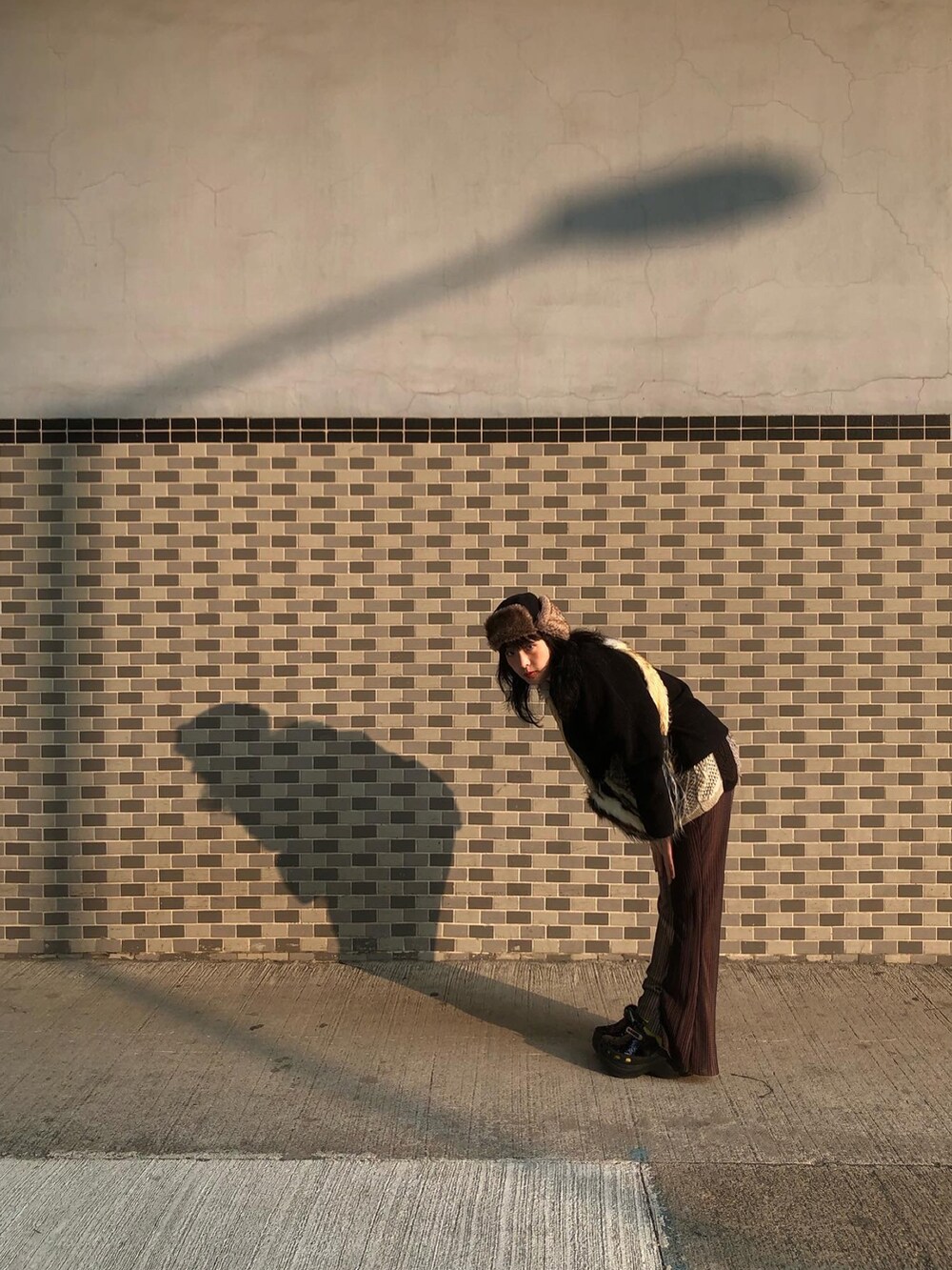 ブラック系のシューズ、ブラウン系のキャップを着用したレディースの冬コーディネートの2枚目の写真