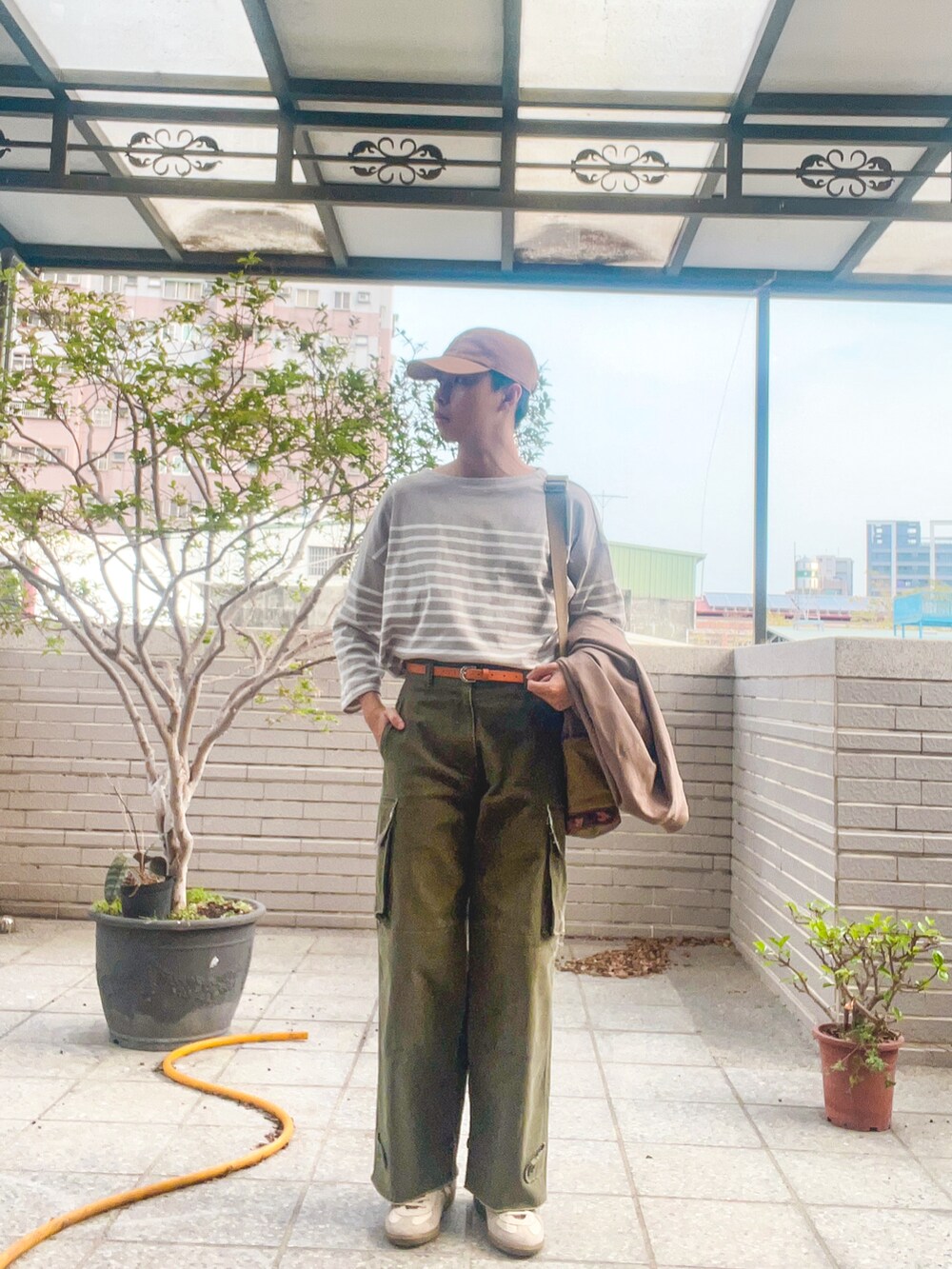 ベージュ系のMA-1、ベージュ系のTシャツ/カットソー、グリーン系のカーゴパンツを着用したメンズの春コーディネートの2枚目の写真