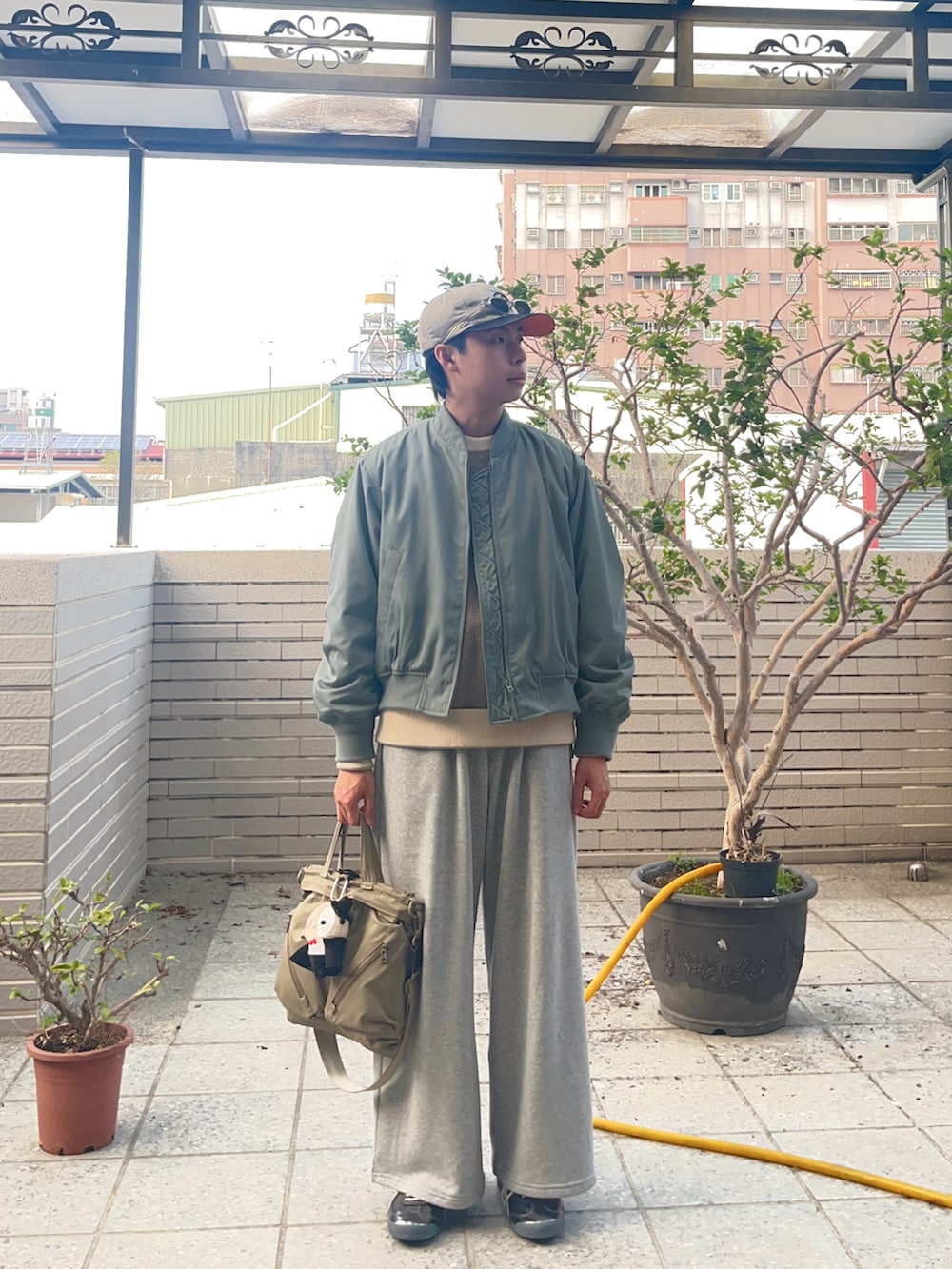 ブラウン系のニット/セーター、グリーン系のジャケット/アウター、グレー系のパンツを着用したメンズの冬コーディネートの2枚目の写真