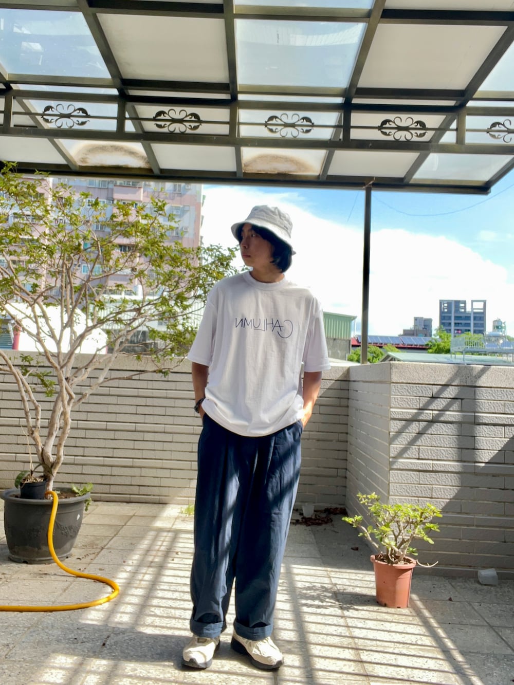 ブルー系のチノパンツ、ホワイト系のTシャツ/カットソー、ホワイト系のスニーカーを着用したメンズの夏コーディネートの2枚目の写真