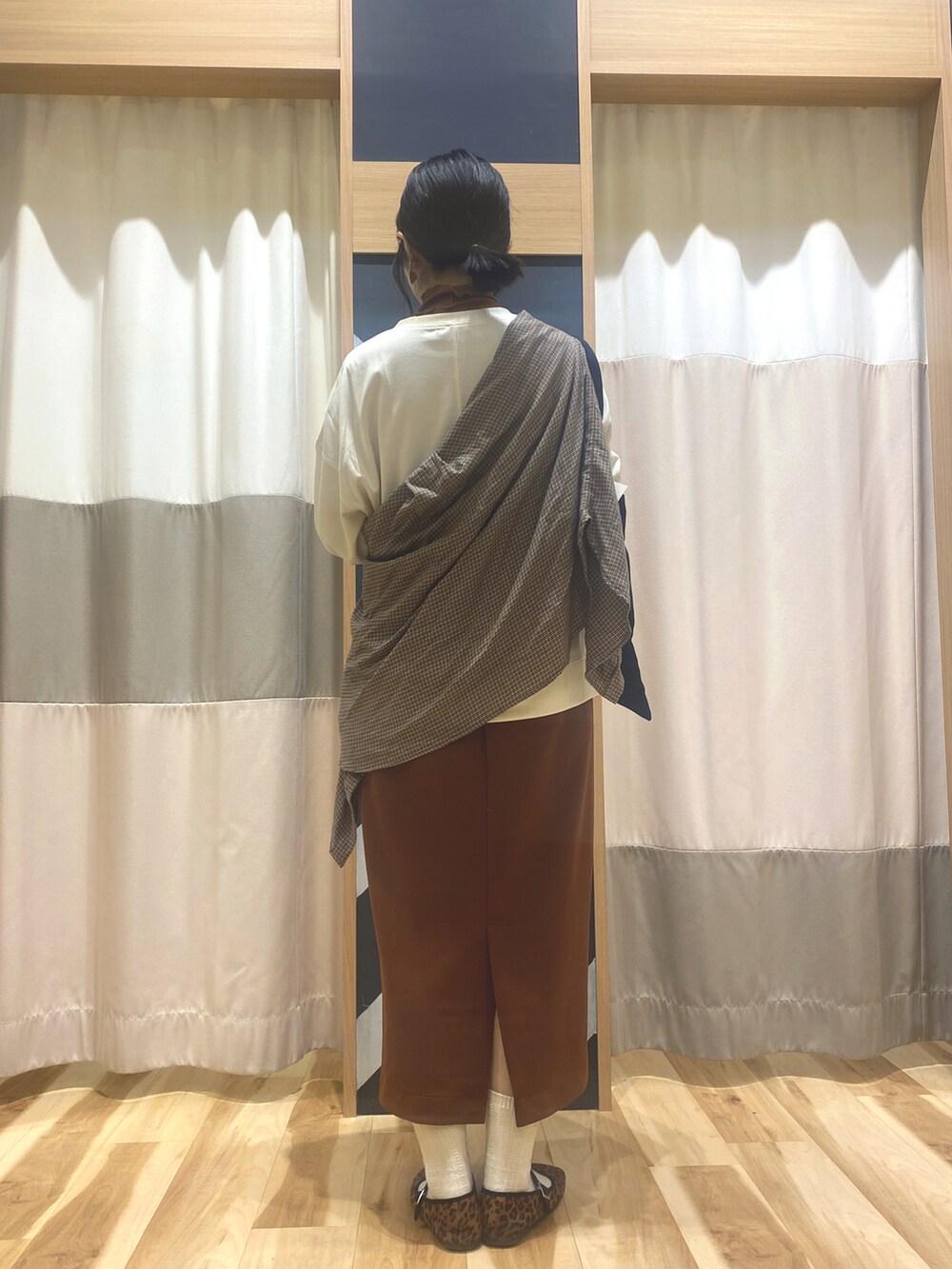 ホワイト系のTシャツ/カットソー、オレンジ系のスカート、ブラウン系のドレスシューズを着用したレディースの秋コーディネートの2枚目の写真