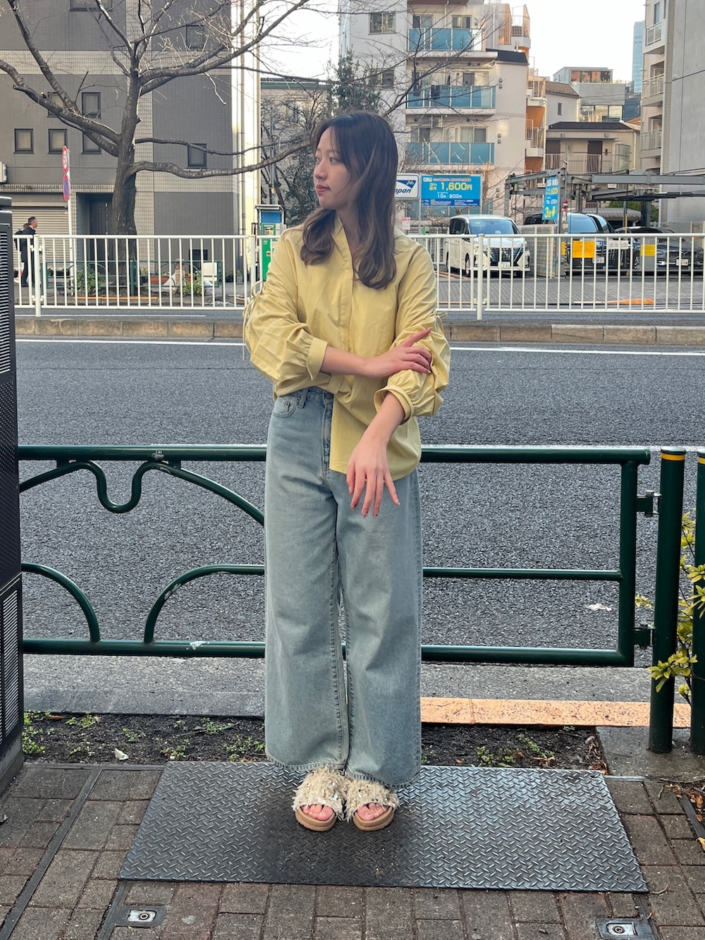 イエロー系のシャツ/ブラウス、ブルー系のデニムパンツ、ホワイト系のサンダルを着用したレディースの冬コーディネートの2枚目の写真