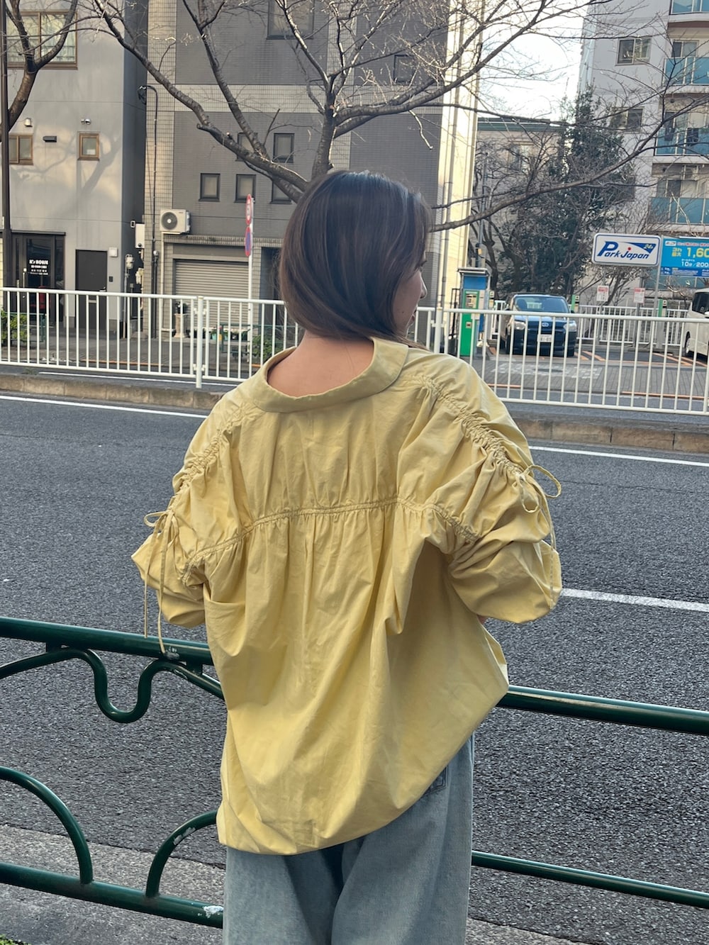 イエロー系のシャツ/ブラウス、ブルー系のデニムパンツ、ホワイト系のサンダルを着用したレディースの冬コーディネートの4枚目の写真