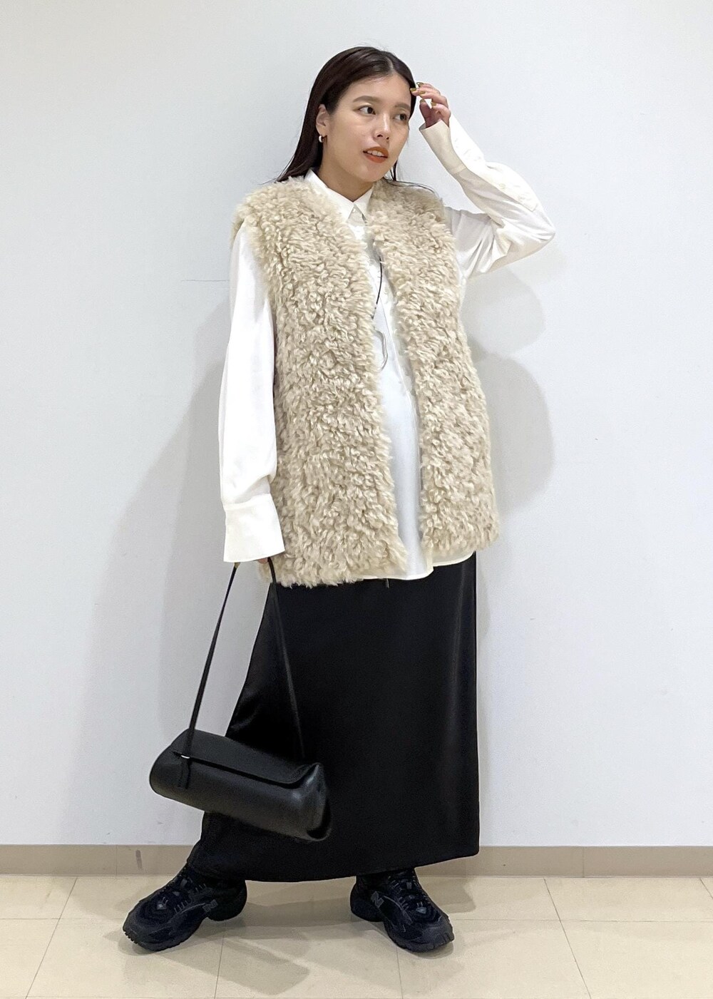 ベージュ系のその他アウター、ブラック系のショルダーバッグ、ブラック系のスニーカーを着用したレディースの秋コーディネートの3枚目の写真