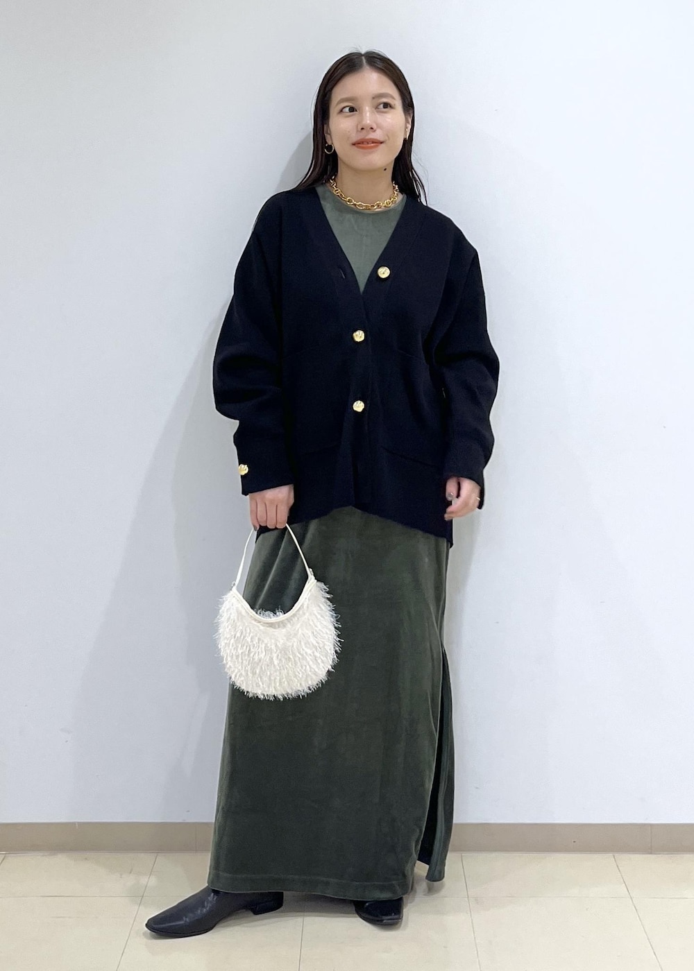 ブラック系のカーディガン/ボレロ、グリーン系のワンピース、ホワイト系のショルダーバッグを着用したレディースの秋コーディネートの3枚目の写真