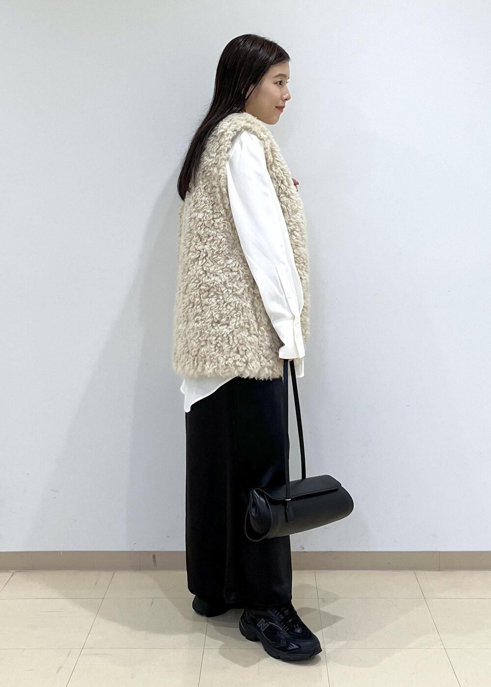 ベージュ系のその他アウター、ブラック系のショルダーバッグ、ブラック系のスニーカーを着用したレディースの秋コーディネートの6枚目の写真