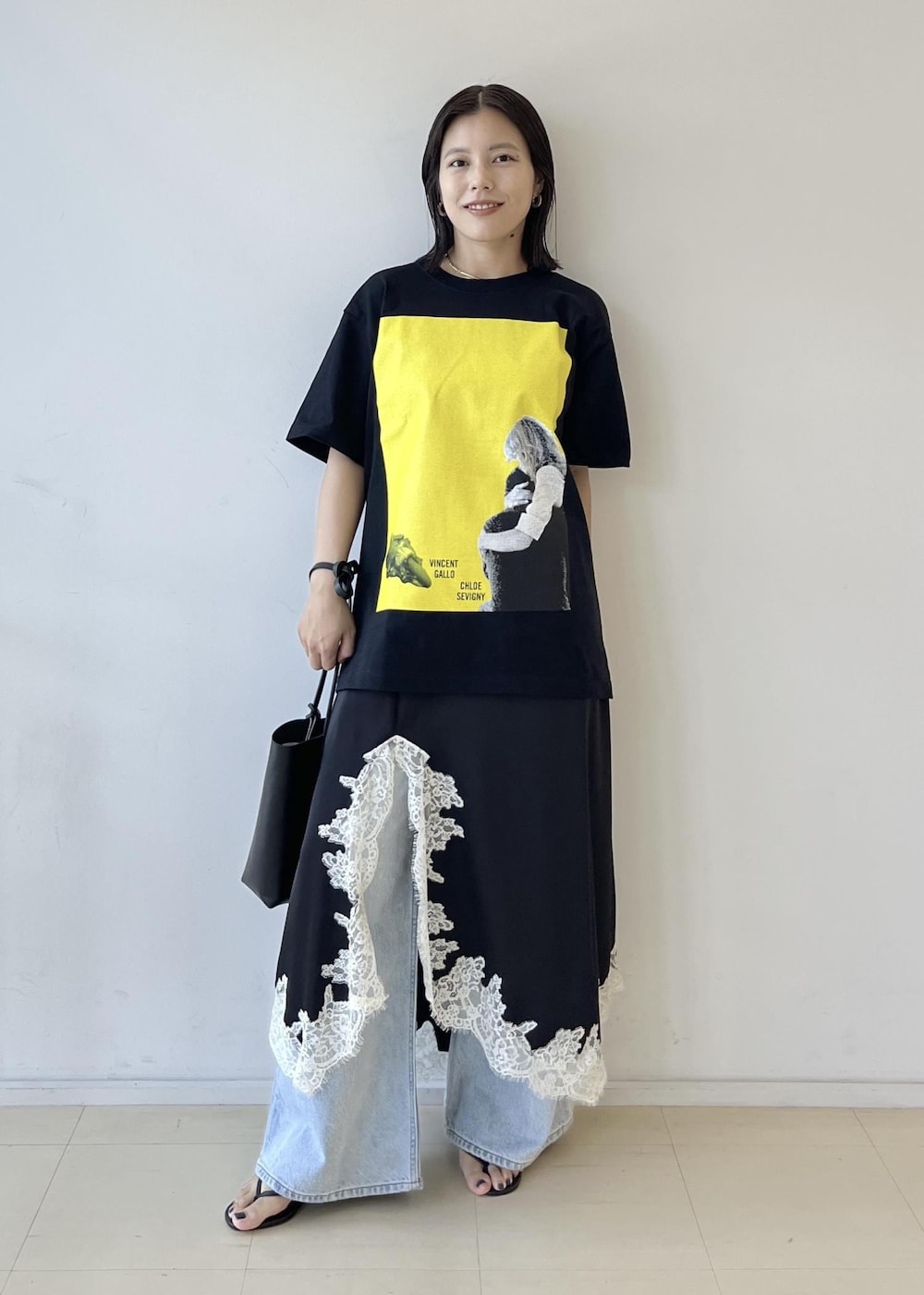ブラック系のスカート、ブラック系のショルダーバッグ、グレー系のTシャツ/カットソーを着用したレディースの夏コーディネートの2枚目の写真