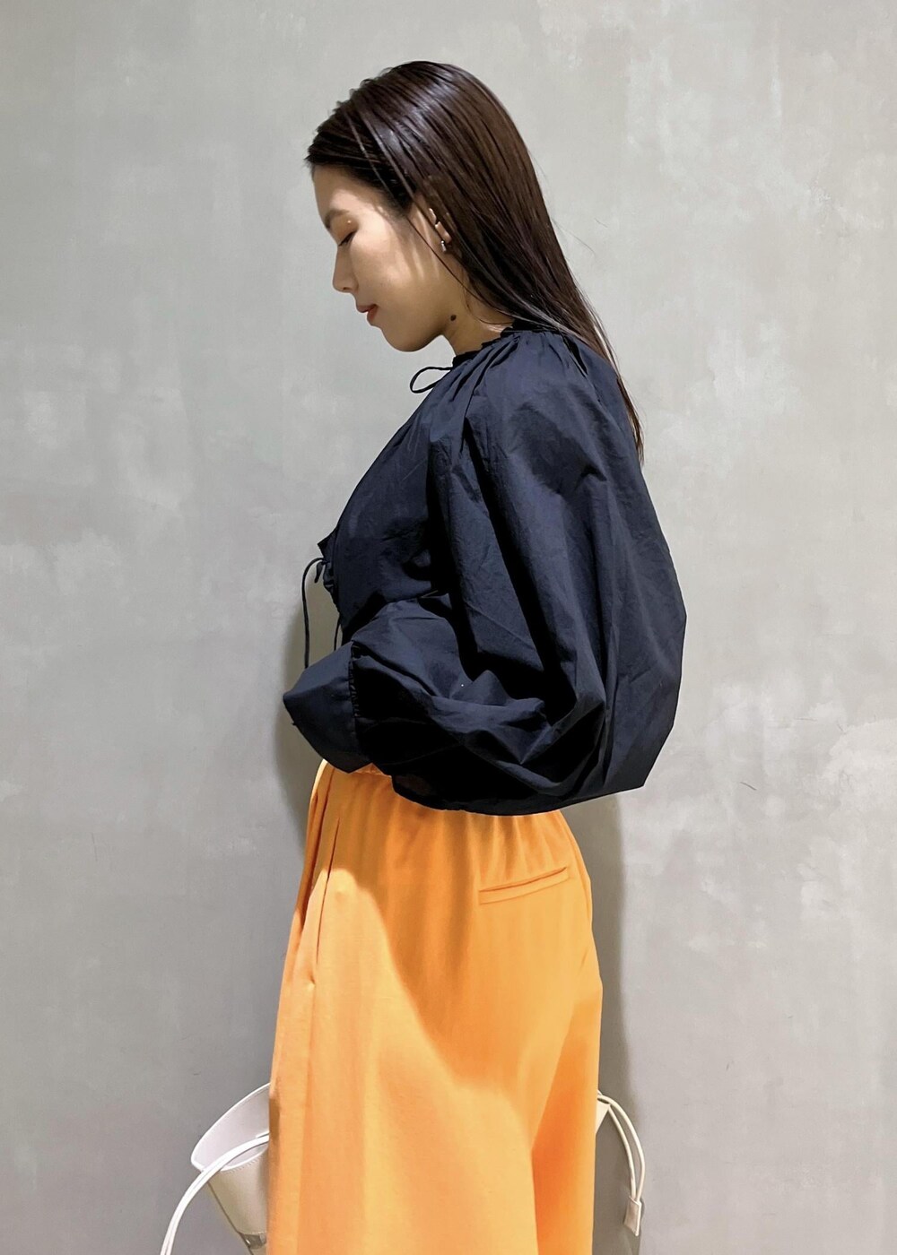 ブラック系のサンダル、ホワイト系のトートバッグ、オレンジ系のその他パンツを着用したレディースの春コーディネートの7枚目の写真