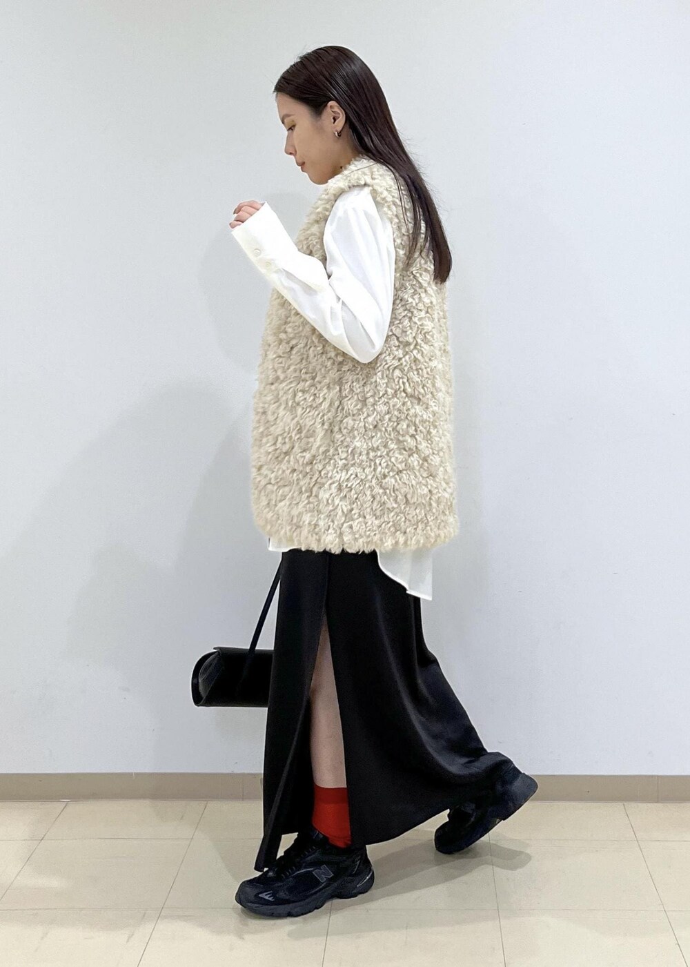 ベージュ系のその他アウター、ブラック系のショルダーバッグ、ブラック系のスニーカーを着用したレディースの秋コーディネートの4枚目の写真