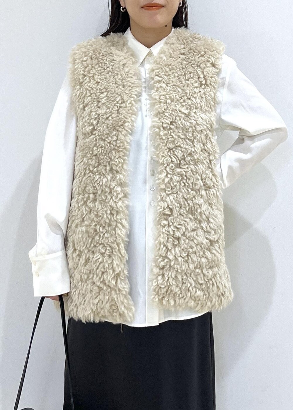 ベージュ系のその他アウター、ブラック系のショルダーバッグ、ブラック系のスニーカーを着用したレディースの秋コーディネートの7枚目の写真