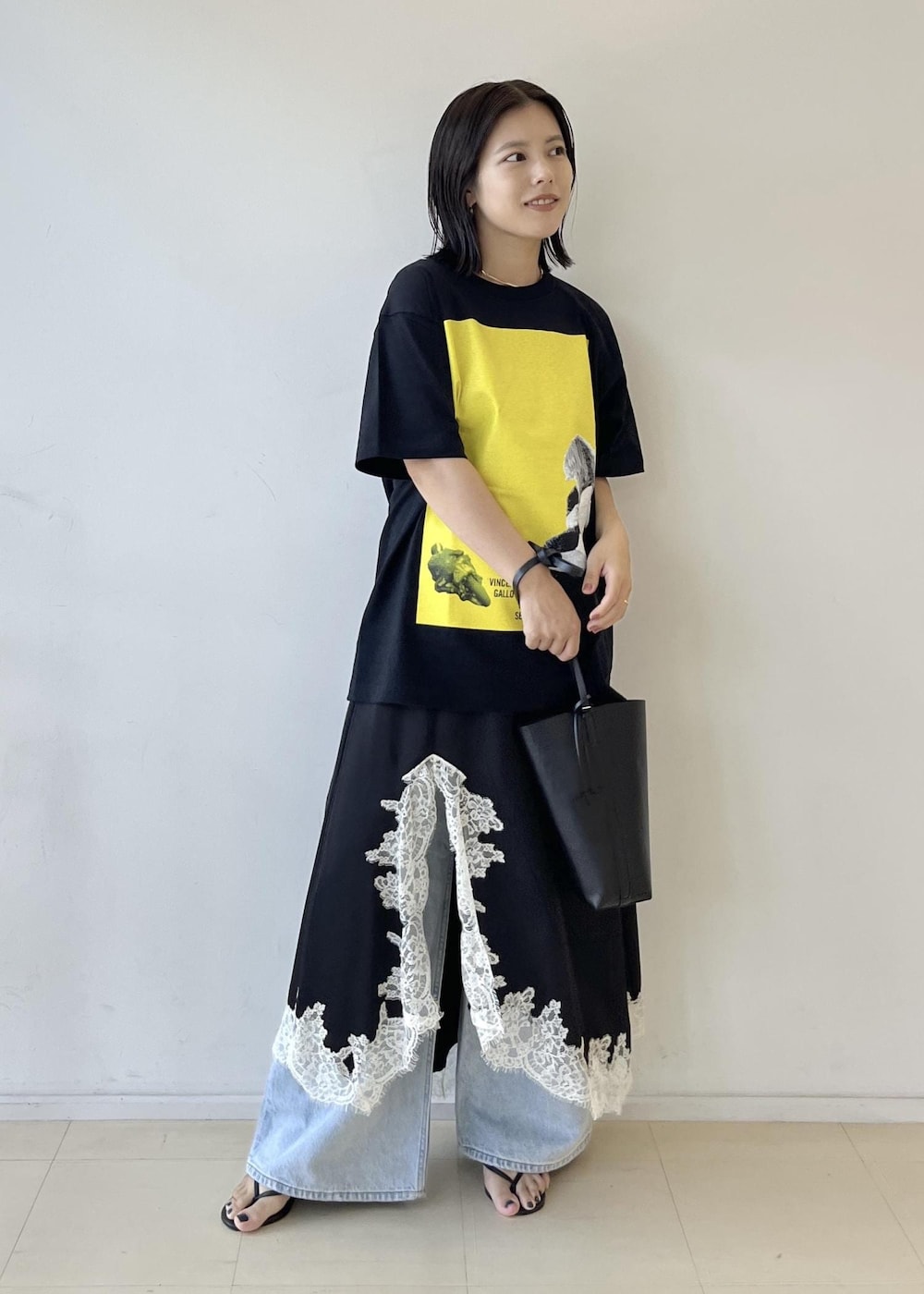 ブラック系のスカート、ブラック系のショルダーバッグ、グレー系のTシャツ/カットソーを着用したレディースの夏コーディネートの3枚目の写真