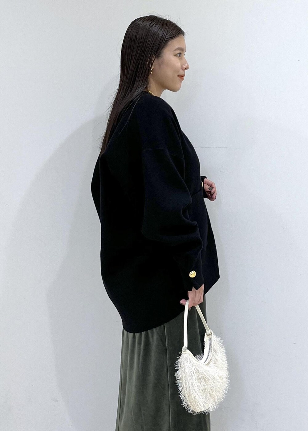 ブラック系のカーディガン/ボレロ、グリーン系のワンピース、ホワイト系のショルダーバッグを着用したレディースの秋コーディネートの10枚目の写真