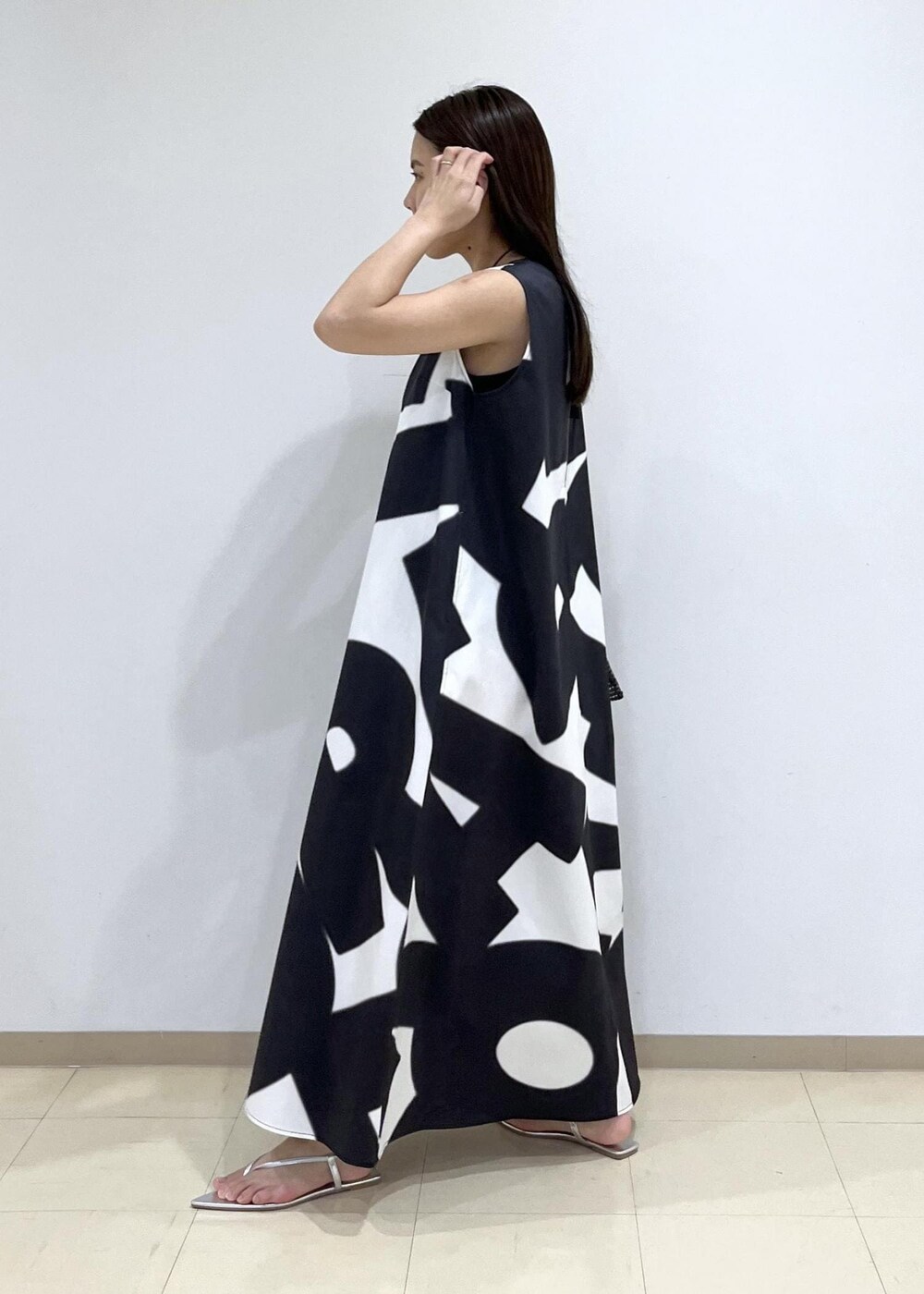 ブラック系のハンドバッグ、シルバー系のサンダル、ブラック系のワンピースを着用したレディースの夏コーディネートの3枚目の写真