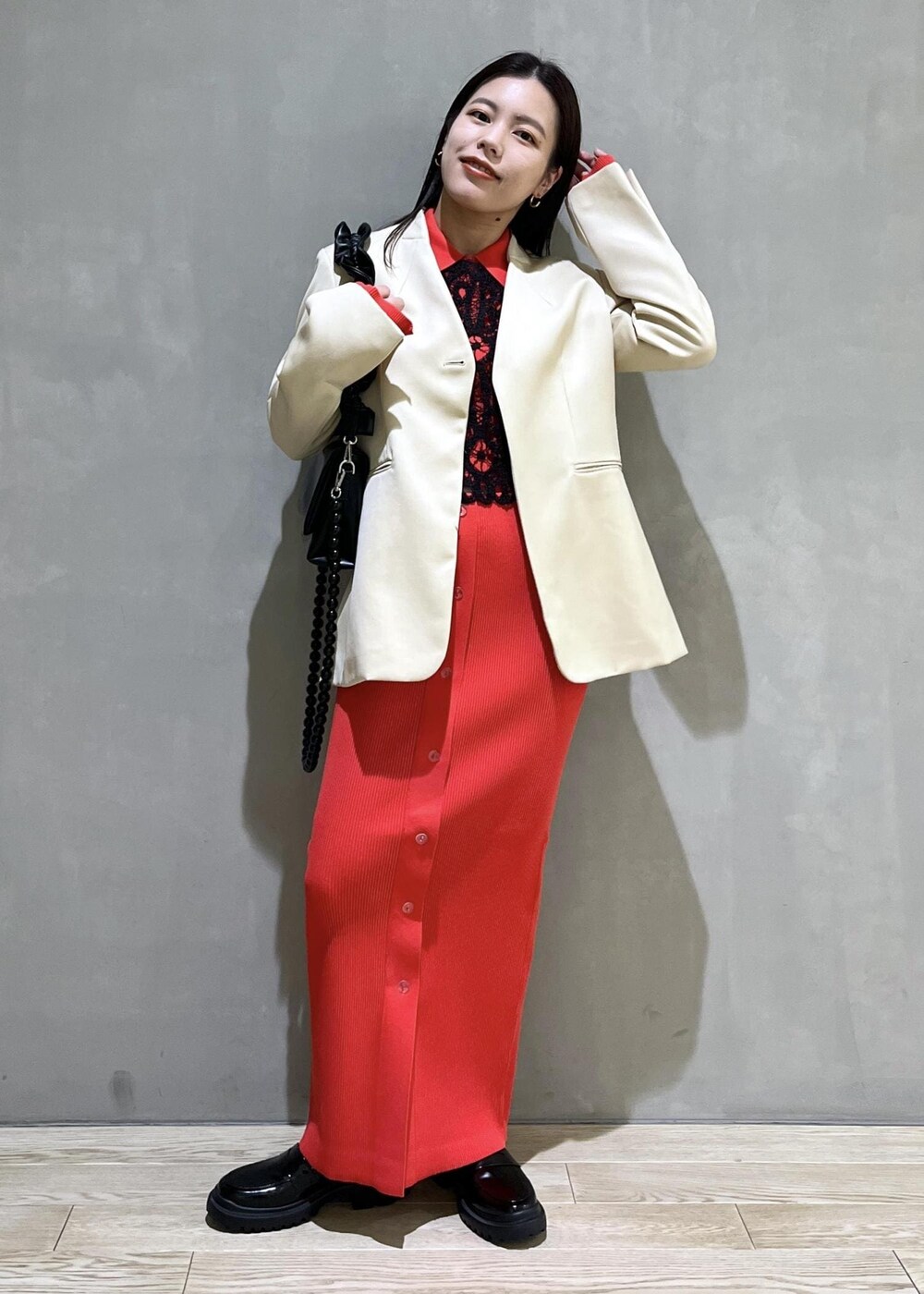 ブラック系のローファー、レッド系のスカート、レッド系のカーディガン/ボレロを着用したレディースの冬コーディネートの2枚目の写真