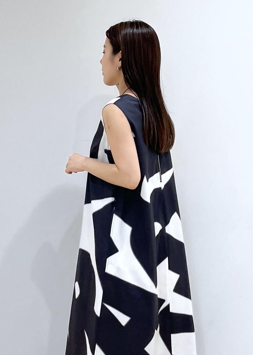 ブラック系のハンドバッグ、シルバー系のサンダル、ブラック系のワンピースを着用したレディースの夏コーディネートの7枚目の写真