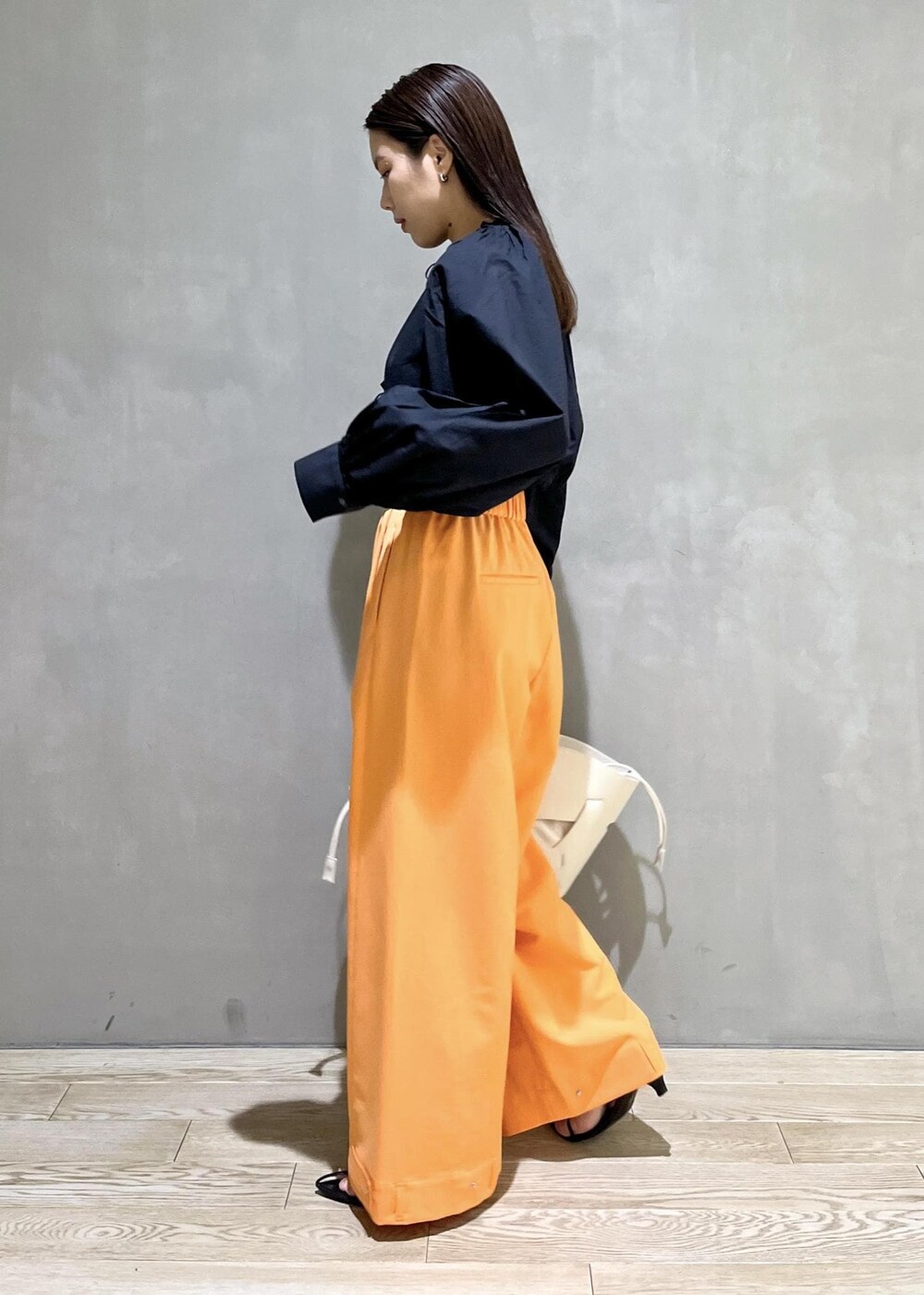 ブラック系のサンダル、ホワイト系のトートバッグ、オレンジ系のその他パンツを着用したレディースの春コーディネートの3枚目の写真