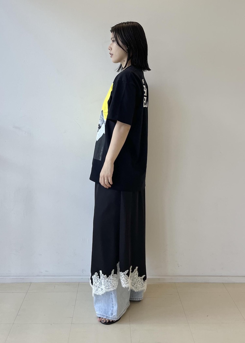 ブラック系のスカート、ブラック系のショルダーバッグ、グレー系のTシャツ/カットソーを着用したレディースの夏コーディネートの4枚目の写真