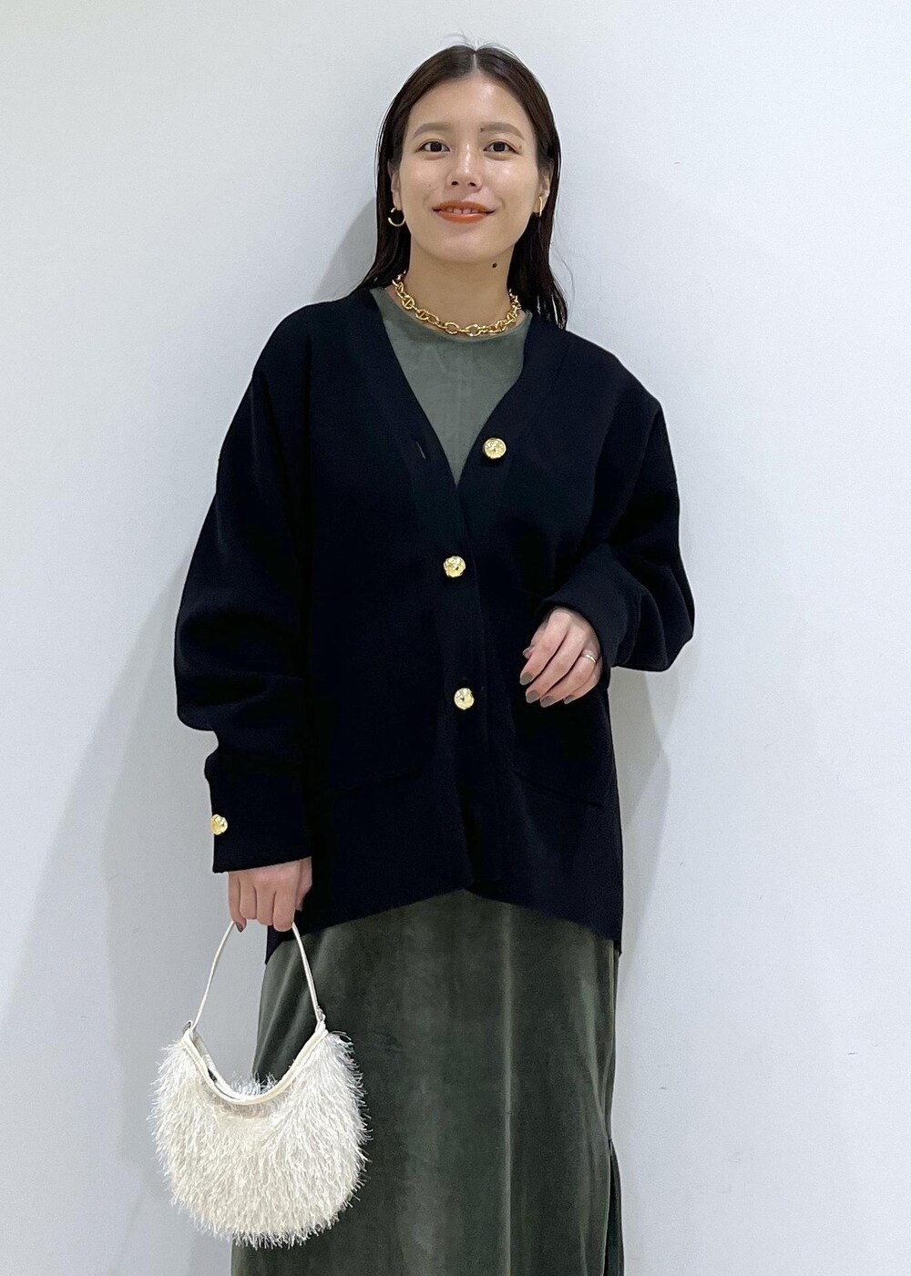 ブラック系のカーディガン/ボレロ、グリーン系のワンピース、ホワイト系のショルダーバッグを着用したレディースの秋コーディネートの7枚目の写真