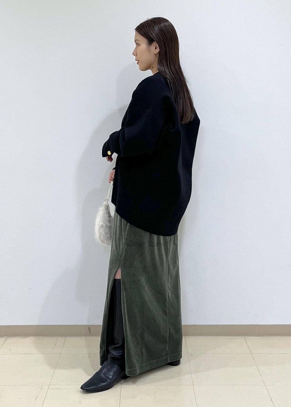 ブラック系のカーディガン/ボレロ、グリーン系のワンピース、ホワイト系のショルダーバッグを着用したレディースの秋コーディネートの4枚目の写真