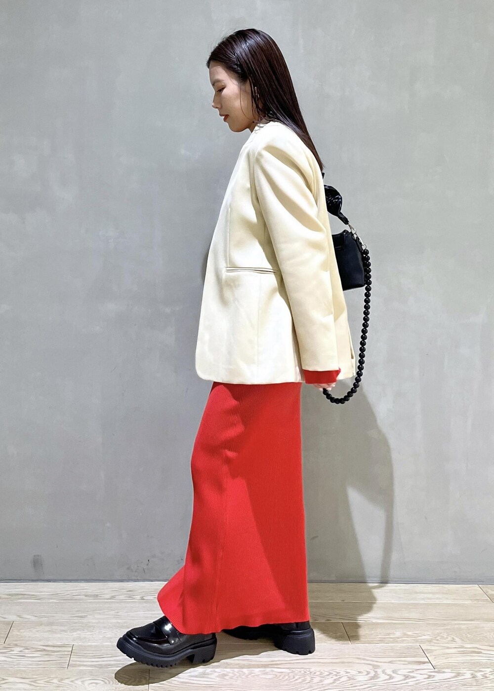 ブラック系のローファー、レッド系のスカート、レッド系のカーディガン/ボレロを着用したレディースの冬コーディネートの3枚目の写真