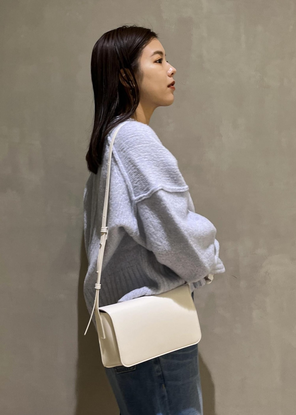 ブルー系のニット/セーター、ブルー系のデニムパンツ、ホワイト系のTシャツ/カットソーを着用したレディースの秋コーディネートの8枚目の写真