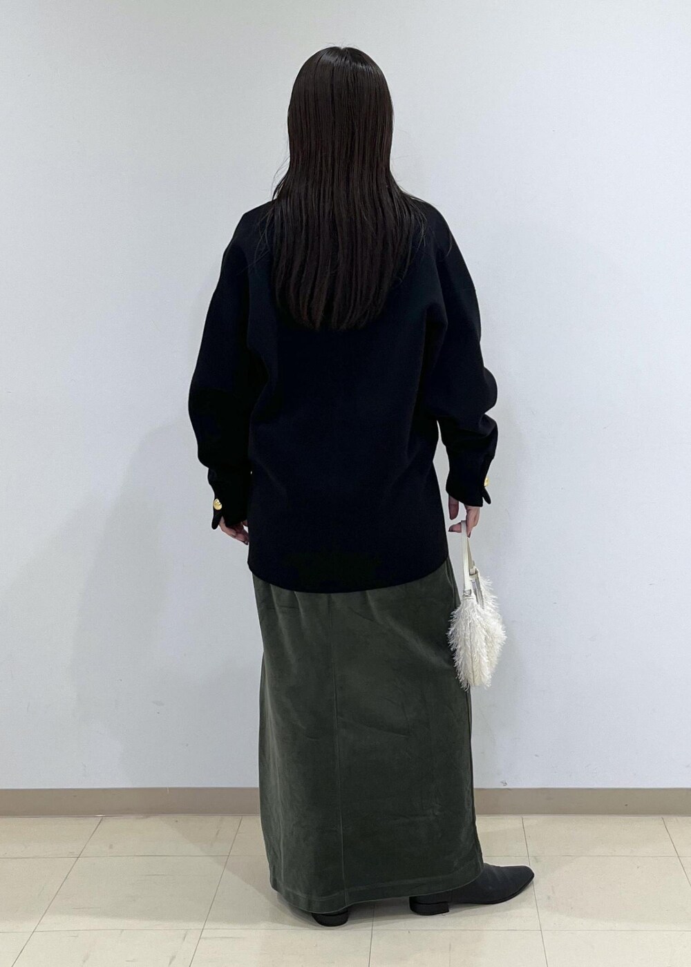 ブラック系のカーディガン/ボレロ、グリーン系のワンピース、ホワイト系のショルダーバッグを着用したレディースの秋コーディネートの5枚目の写真