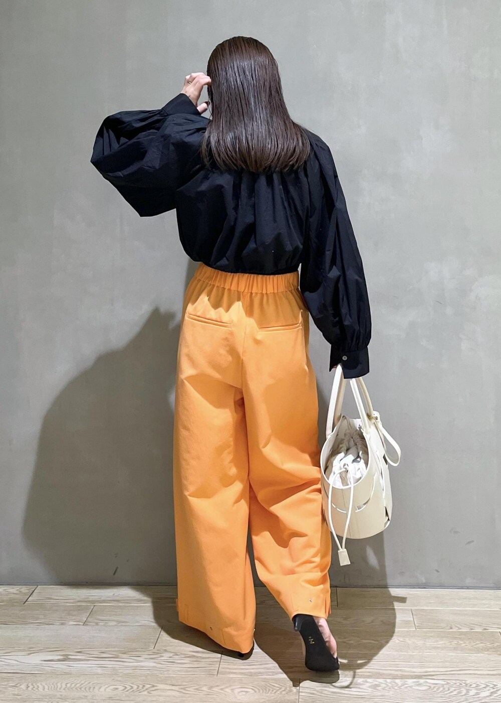 ブラック系のサンダル、ホワイト系のトートバッグ、オレンジ系のその他パンツを着用したレディースの春コーディネートの4枚目の写真