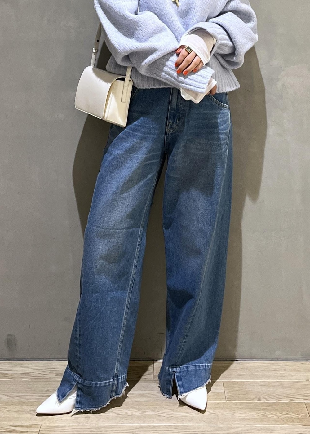 ブルー系のニット/セーター、ブルー系のデニムパンツ、ホワイト系のTシャツ/カットソーを着用したレディースの秋コーディネートの9枚目の写真