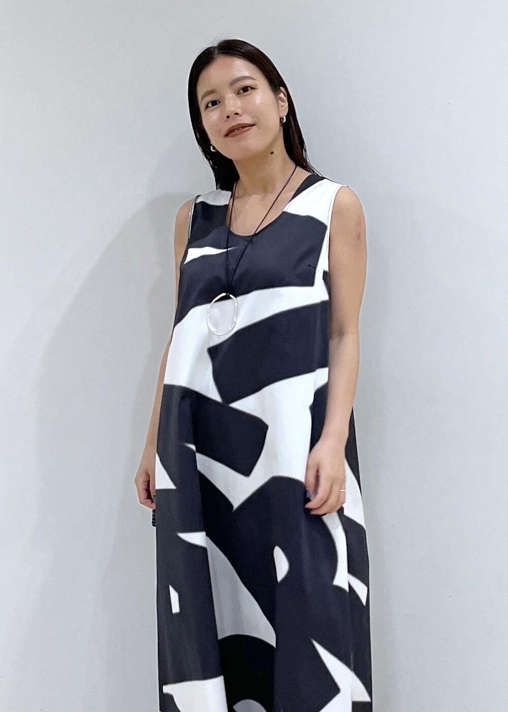 ブラック系のハンドバッグ、シルバー系のサンダル、ブラック系のワンピースを着用したレディースの夏コーディネートの6枚目の写真