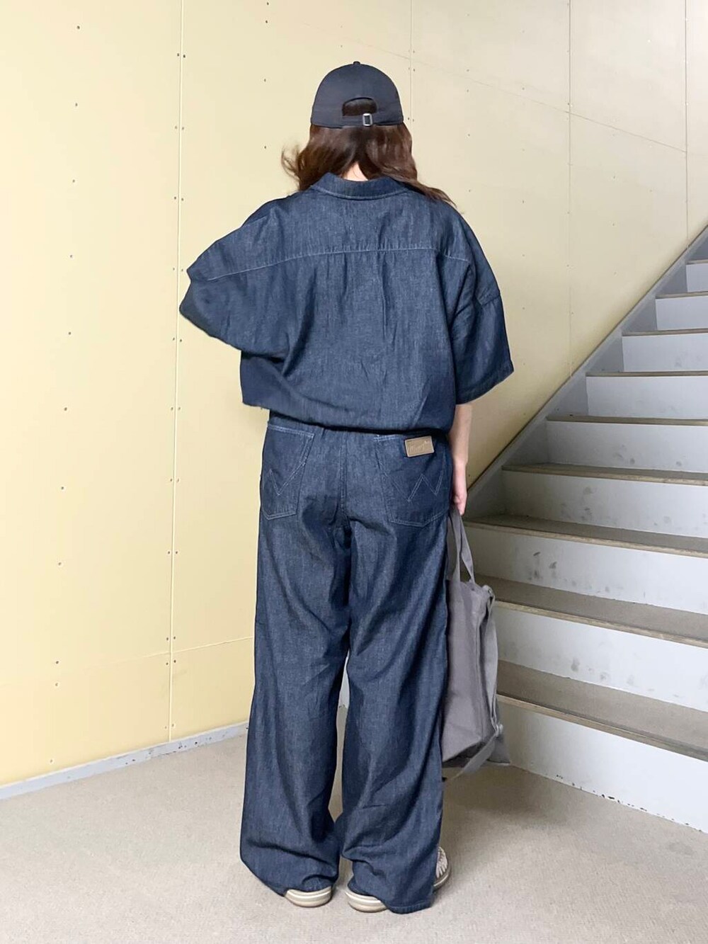 ホワイト系のタンクトップ、ブルー系のシャツ/ブラウス、ブルー系のデニムパンツを着用したレディースの春コーディネートの3枚目の写真