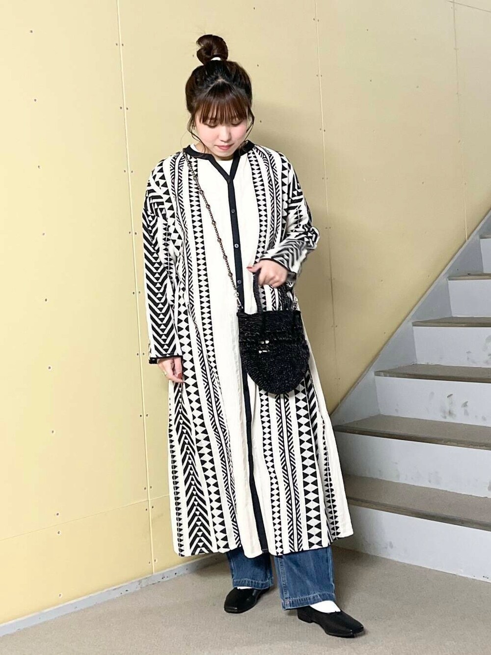 ブルー系のデニムパンツ、ブラック系のバレエシューズ、ブラック系のショルダーバッグを着用したレディースの春コーディネートの3枚目の写真