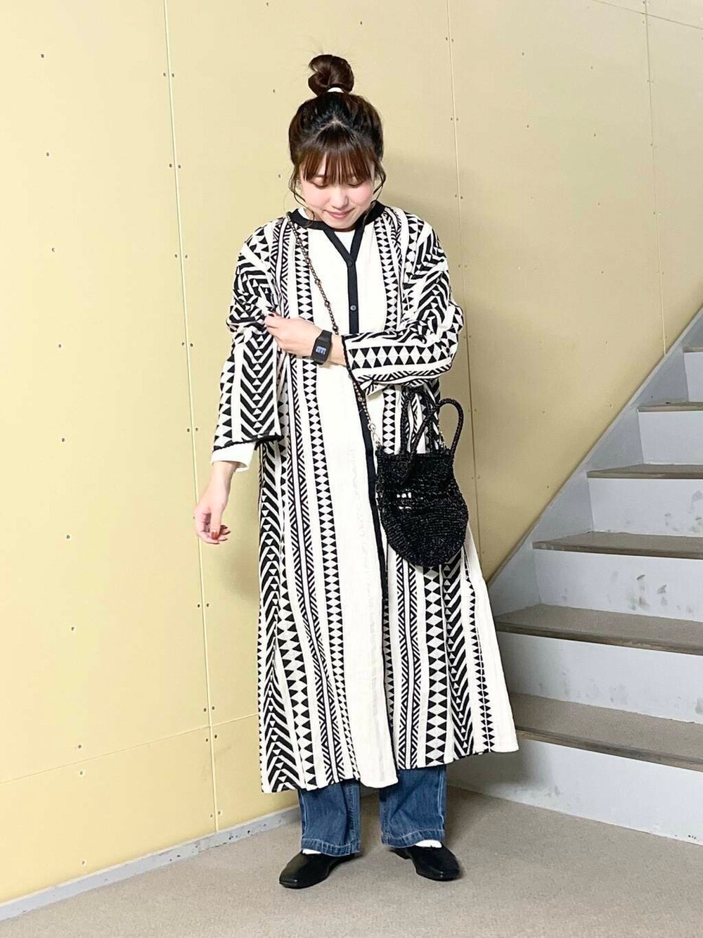 ブルー系のデニムパンツ、ブラック系のバレエシューズ、ブラック系のショルダーバッグを着用したレディースの春コーディネートの2枚目の写真