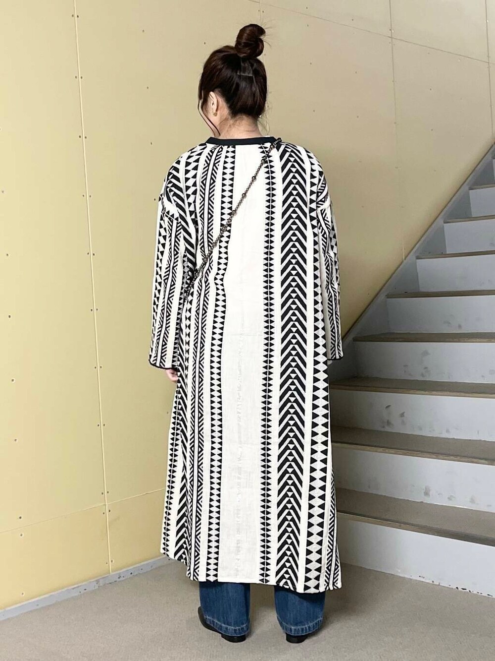 ブルー系のデニムパンツ、ブラック系のバレエシューズ、ブラック系のショルダーバッグを着用したレディースの春コーディネートの4枚目の写真