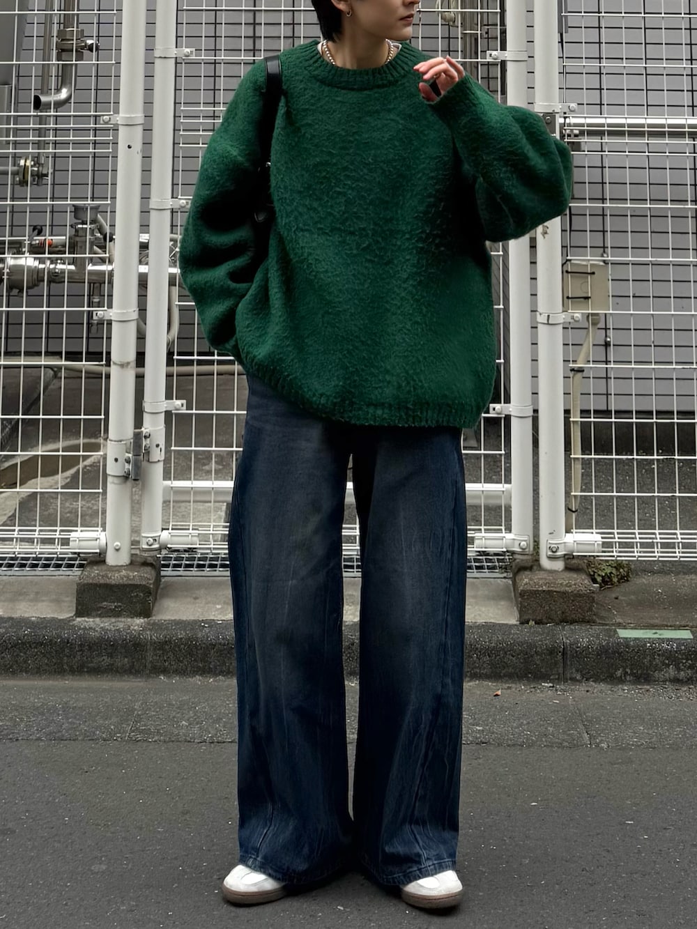 グリーン系のニット/セーター、ブルー系のデニムパンツ、ホワイト系のスニーカーを着用したメンズの冬コーディネートの2枚目の写真