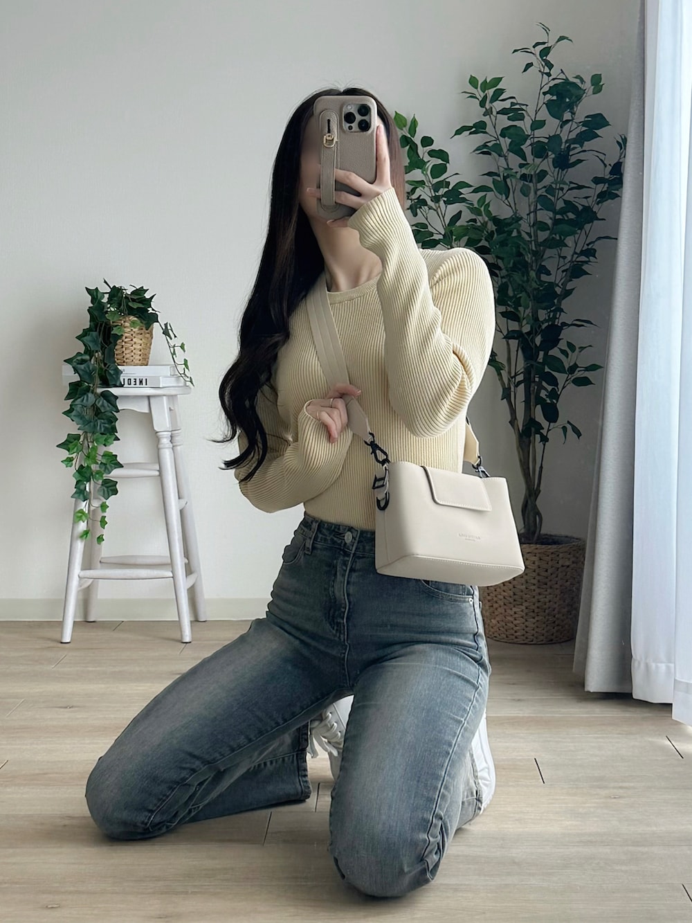 ホワイト系のショルダーバッグ、イエロー系のニット/セーター、グレー系のデニムパンツを着用したレディースの春コーディネートの2枚目の写真