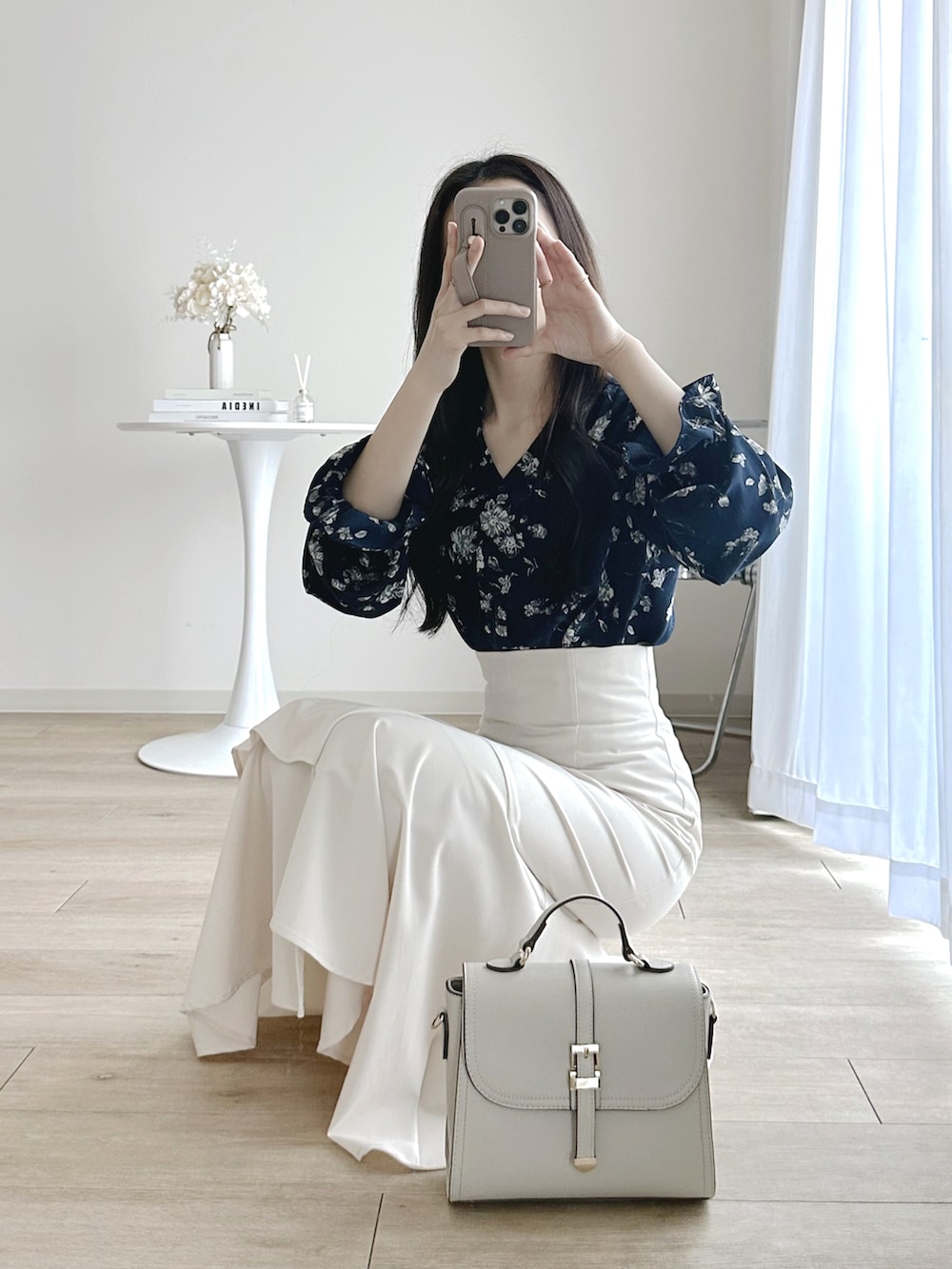 ホワイト系のパンプス、ホワイト系のスカート、ホワイト系のハンドバッグを着用したレディースの春コーディネートの3枚目の写真