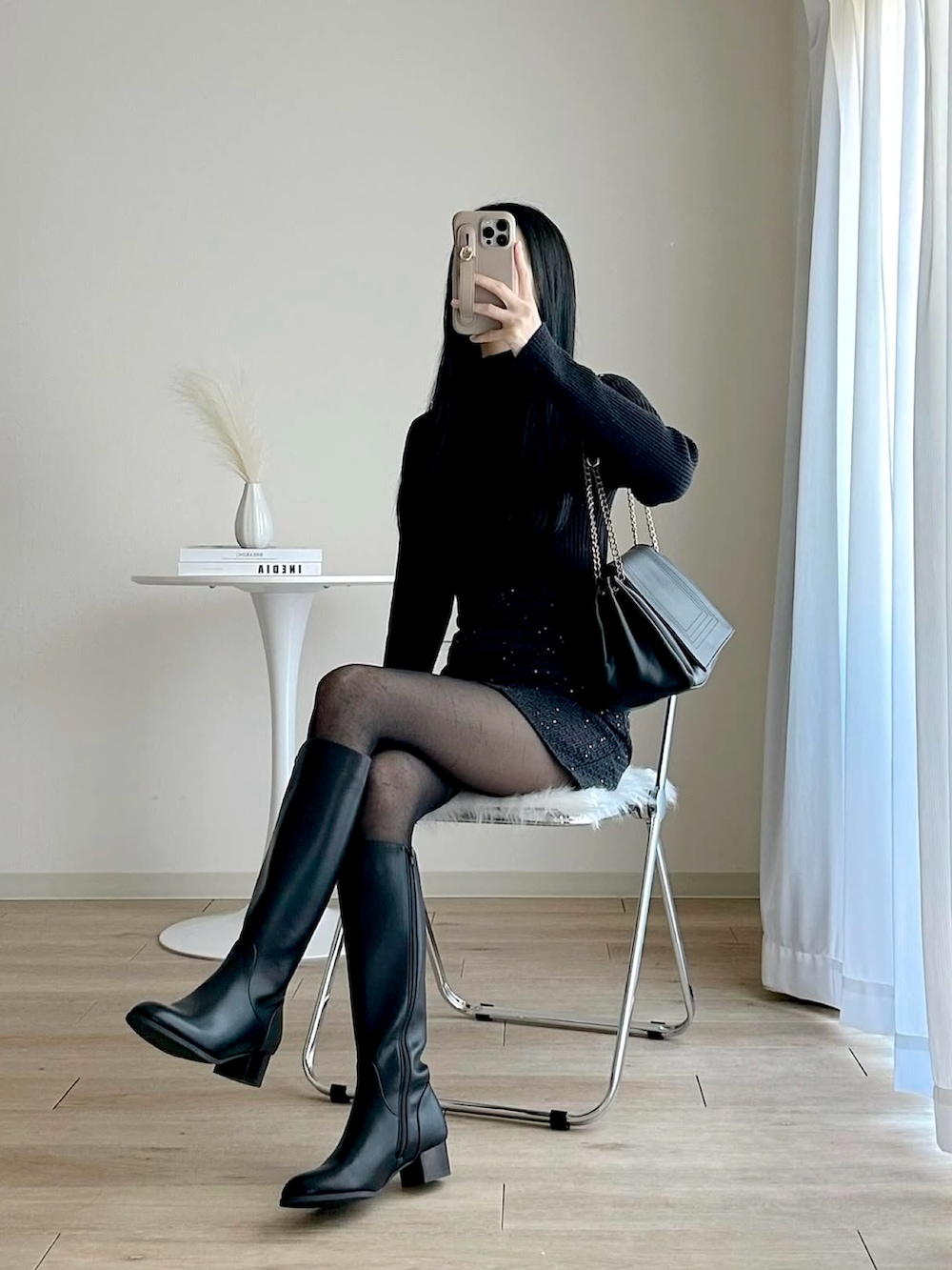 ブラック系のブーツ、ブラック系のスカート、ブラック系のニット/セーターを着用したレディースの冬コーディネートの4枚目の写真